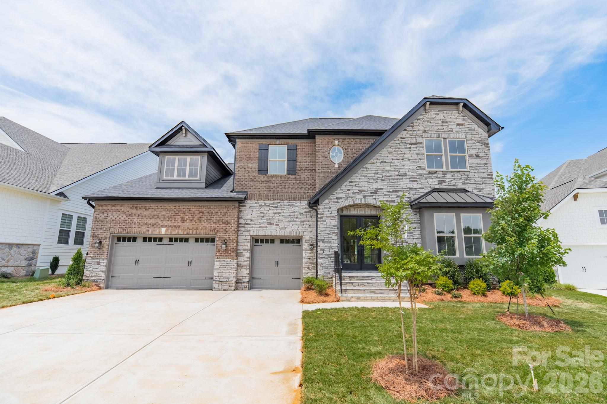 New construction luxury home in Heritage at Marvin. The Summerville floor plan offers approximately 5,155 heated square feet with 6 bedrooms, 6.5 baths, and a 3-car garage.The main kitchen features stacked cabinetry, quartz waterfall island, full-height quartz slab backsplash, pot filler, brushed gold hardware, and a premium appliance package including a 42-inch built-in refrigerator, 6-burner gas range, custom hood, and wall oven/microwave combo. A separate messy kitchen provides additional prep space, storage, and secondary refrigeration.Interior features include a built-in sports bar with island, glass-enclosed wine room, bonus room, and media room. The family room includes a linear fireplace with decorative tile surround, floating wood mantel, and built-in window seating with storage.The primary suite includes a spa-style bath with soaking tub, oversized walk-in shower with rain head and handheld, quartz countertops, and designer tile selections. Secondary bathrooms offer quartz countertops, tiled showers, and comfort-height fixtures. Don't miss this!Additional features include engineered wood flooring, upgraded drop zone, solid-core interior doors, black interior hardware, custom millwork, and designer lighting. Outdoor living spaces include a covered composite lanai with privacy wall and an upper-level covered rear balcony.