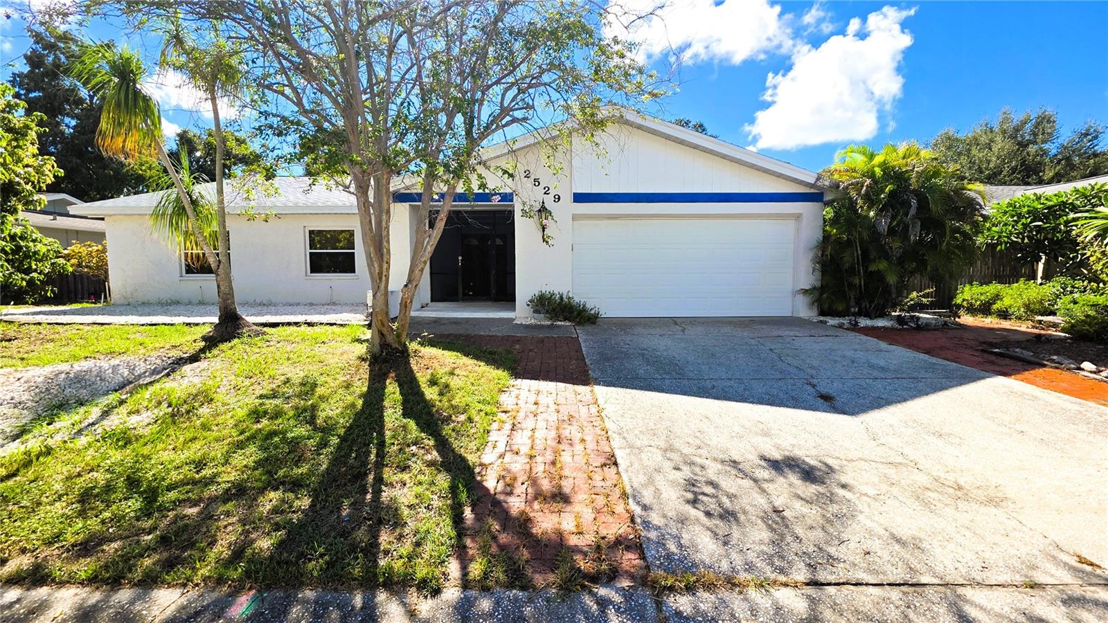 Come and look at this gorgeous remodeled four bedrooms two bathrooms, almost 2000 square feet single family home located in unincorporated Dunedin Florida. This home has been meticulously maintained and remodeled throughout the years. This house boasts a new roof in 2025, newer double pane impact windows and sliding doors, (there is a finalized 2016 permit public records). When you are about to enter, you will notice right away that you are looking at something special, you will be welcomed by a screened-in large front porch for privacy, and inside you will walk through a formal entry corridor that opens up directly to the main living area.The main living room has been set up by the current owner, with a large couch and TV area with views to the pool area, with a sitting area by the firepla & 2 sofas, and finally with a large dining table that can sit eight guests & more. Please notice the vaulted ceilings that will give you plenty of spaceto enjoy your day! You will not certainly feel constricted. This house is full of light and feels very spacious with its high ceilings. From the living room youwill notice an large opening that leads you into a semi-separate area with the house kitchen, with its solid wood cabinets and granite countertops and a large eating space that could also be used as a secondary family room. This connects to the private in-house laundry room and the two car garage.On the opposite side of the house, the large primary bedroom is located on the pool side and its en-suite bath has been remodeled with a mid-century modern twist, then there are the three guest bedrooms and the guest bath with its two new vanities.There are wood floors throughout the living room and two bedrooms, then matching laminate floor in one bedroom and tiles in the fourth bedroom, while  the kitchen and the family room have neutral tiles floors. Last but not least, the house boasts a very large caged-in pool, with access to the incredible backyard that gives you amazing views of a large untouched wooded area owned by the City of Dunedin. There is a small creek in the back called Jerry Branch that is a small natural tributary to Curlew creek and serves its purpose as a storm water drainage canal for the neighborhood, so you do not have to worry! If you look at the flood map, all the house is located in a X500 zone, that is not a flood area, but the rest of the backyard is in a flood zone AE, therefore if you have a lender they will require flood insurance. When the current owner bought it, they did have to bind flood insurance as well but it was minimal at the time, I can provide more information upon request. The house did not flood during hurricane Helene. This property has a well and a connected irrigation system!Barrington Hills in Dunedin is conveniently located near Countryside Mall (1.7 miles away) and all its shopping venues and also not far from Downtown Dunedin (2.9 miles) with all its Restaurants and charm, Tampa International Airport is 18 miles away.
