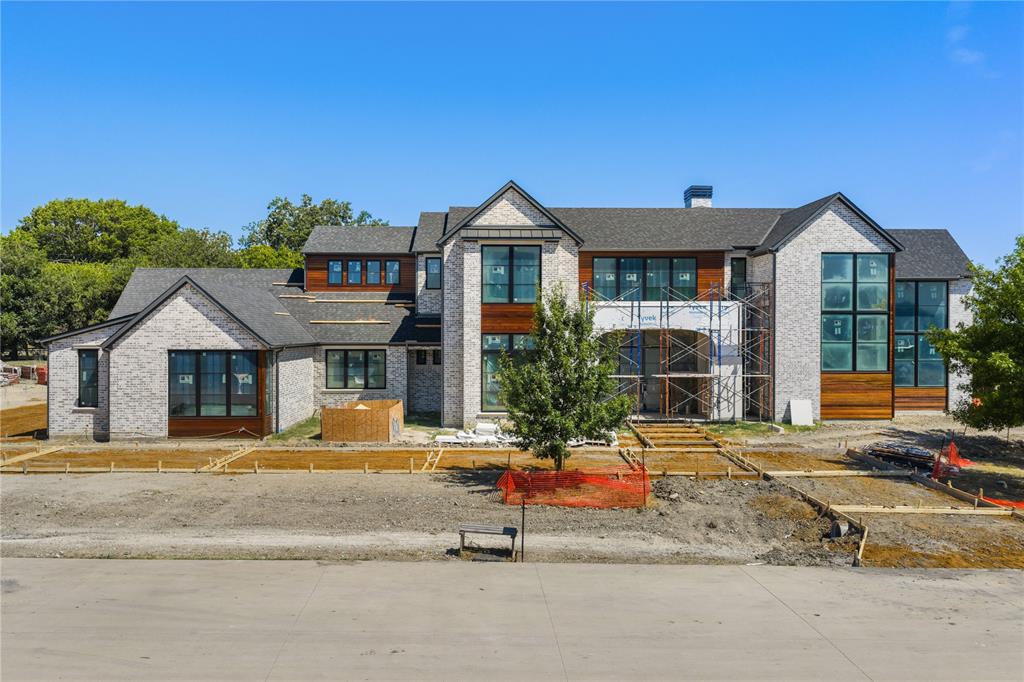 Brand-new construction by Tim Jackson Custom Homes, one of North Texas's most respected luxury builders for three decades, on a private 1.2-acre lot in Twin Oaks, an exclusive nine-home enclave in Fairview built around a community pond, water features, and a walking trail, all within top-ranked Lovejoy ISD. The 8,091-square-foot modern traditional design combines painted brick and cast stone with standing-seam metal roof accents, a two-story entry, and tall steel-framed windows. Inside, a brick-paver foyer and floating staircase open to a great room with a gas fireplace, which connects to a kitchen finished with Sub-Zero, Wolf, and Cove appliances, custom cabinetry, and a quartzite island, where the farm sink looks out over the pool. A full prep kitchen and walk-in pantry handle the work behind the scenes. Off the main living areas, a wine room sits near the entry, and a brick-walled study offers built-ins and a spiral stair up to a private loft. The first-floor primary suite includes a sitting area set off by a see-through fireplace and a marble bath with a freestanding tub, oversized shower, dual vanities, and two walk-in closets. A guest suite sits on the main level, and upstairs, three more ensuite bedrooms, a second living room, a game room, and a carpeted media room with a wet bar. Two powder baths and separate upstairs and downstairs laundry rooms complete the plan. Out back, there's a pool with a raised spillover spa, a two-story covered loggia with motorized retractable screens, an outdoor kitchen, and a firepit, all framed by mature trees with full irrigation, fencing, and dark-sky lighting. Built with full spray-foam encapsulation, Energy Star efficiency, a Lennox Signature Series HVAC system, structured wiring, and an oversized four-car garage with epoxy floors, this is a brand-new custom estate on a private acre-plus in one of Fairview's most premier communities.