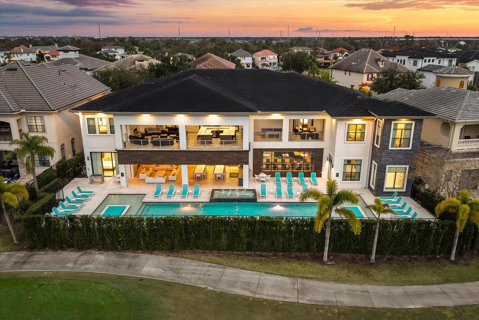 REUNION RESORT MEMBERHIP PROPERTY. Luxury, Lifestyle and Legacy- This is Reunion Resort and now this is your chance to own a true Reunion legacy property located at 350 Muirfield Loop. This is a custom built 12-bedroom, 12 full bath, 2 half bath, golf course view home that is located on a highly desirable double lot inside one of the most revered areas in all of Reunion, Legends Corner. Overlooking the 10th hole of the Nicklaus Golf Course, this home possesses undeniable curb appeal and comes in at 13,000 square feet of living, entertaining, and memory making space. Once inside the home you instantly find yourself wanting to discover all of its secrets. Starting with the first floor that boasts a grand use of space and helps to redefine what open floor plans really should look like. Starting with a kitchen area that is ready to take on any size meal and is outfitted by multiple appliances, dual sinks, separate eating and dining areas, and finished in high end cabinetry and custom features. The living room size and layout then creates the perfect back drop for relaxation and great conversations. All of this is framed by floor to ceiling sliding glass doors that capture every available drop of sunlight that this West facing pool home property allows. Also please pay close attention to the detail of the ceilings in this home with the custom designed lighting and coffered features, its just that extra touch. 5 of the homes 12 bedrooms are on the FIRST FLOOR including the Primary Bedroom and Bath. The primary bath’s space is designed specifically to promote serenity and relaxation with a dedicated space for a private soaking tub. This home also provides the luxury of having your own “in home” private gym and work-out area that includes an array of training equipment.  Yes, the first floor is impressive, but wait till you visit the second level of this property. To gain access there are dual staircases. In  the 7 professionally designed and decorated additional bedrooms you will find rooms capturing different themes with features like Castles and Princesses, Underwater Adventures and one room will even put you in the cockpit of a TIE Fighter before having you traveling at the speed of light! All in a day’s work for a home like this. If you are lucky enough to find the “secret room” on the second floor then welcome to your private arcade space, no quarters required! The private in home theatre room seats 12 comfortably. The 2nd floor showcases 14ft ceilings and is a dazzling display of how you build a home to entertain.  The space spills out on to a custom screened second floor balcony area that is one of the largest balconies in all of Reunion, offering breathtaking sunsets, picturesque golf course vistas and a 360-degree television viewing area that drops down from the ceiling above your custom outdoor bar. This property is home to The iconic “NEON SIGN” that is certainly a Reunion landmark and one that has been admired by many a golfer and patron alike.   Reunion Resort has everything you want in a community including 3 signature golf courses, world class dining, waterparks, lazy river, water slides, firework viewing areas, tree lined streets, dog park, playground, driving range, golf simulator, member events, in-resort shuttle service, and event space. Live the resort lifestyle like a VIP. Minutes to Disney and close to Beaches, Universal, Legoland and Sea World.  Huge rental potential or a great personal use home.