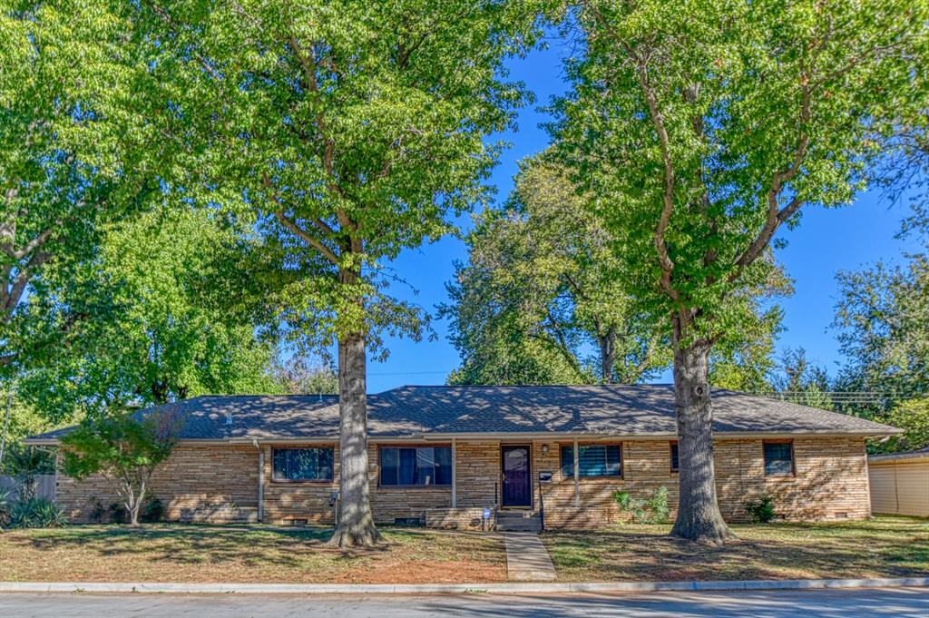 Charming home on an over-sized lot with tons of mature trees and located within just a mile from OU campus! The detached garage is set up with electricity, has a 2-vehicle carport added to it, and overlooks a huge driveway with more than ample parking space! The nice-sized, covered porch provides a welcome feel with room for a sitting space! The back patio opens to a huge yard with possibilities galore! Stepping inside, you are met with a tasteful mix of vintage and contemporary styles! The front room may serve as both a formal dining /living room, depending on your specific needs! The kitchen is partially modernized with updated countertops and fixtures while offering tons of cabinet space, a little desk for the laptop, and breakfast nook for casual dining!! The central living room comes with a cozy wood-burning fireplace, built-in bookshelves, and natural lighting from the large picture window! That room and all 3 bedrooms come with hard-wood flooring. The bathrooms come with classic style, colorful tiling and tub/shower combos. The carpeted extra living area has a ton of closet space, is great for a den/TV room, and allows access to both the back yard and driveway! For added convenience, the home does come with an underground sprinkler system! Updated electrical, plumbing fixtures, and windows help the energy efficiency! Seasonal lawn maintenance included with rent.