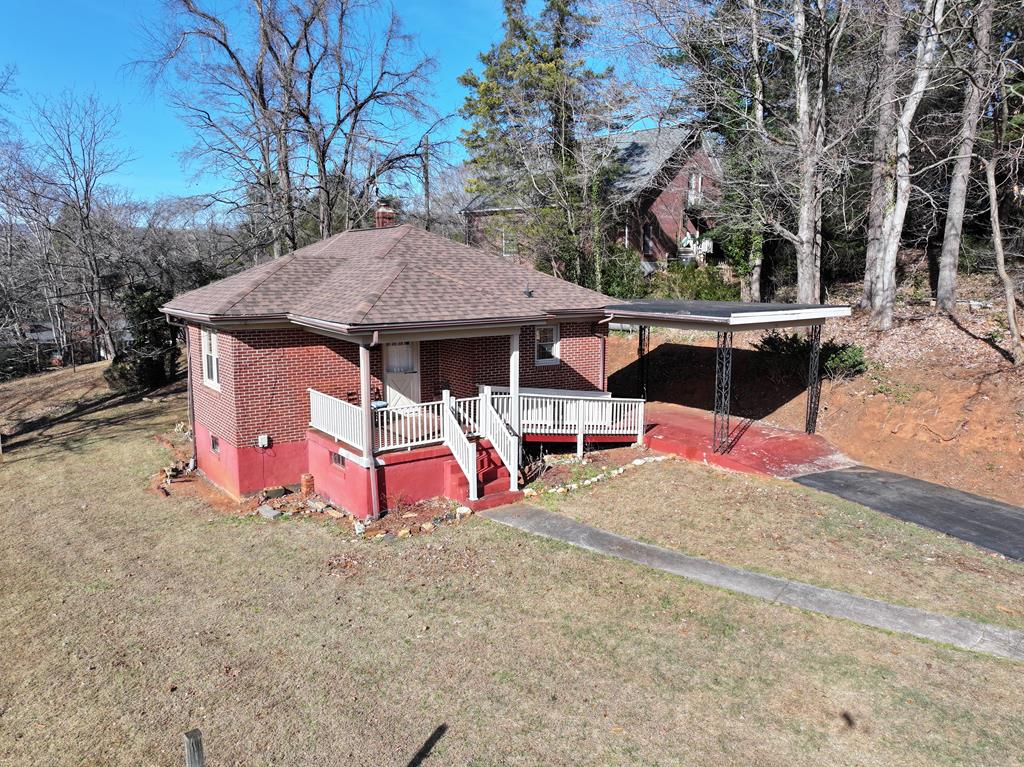 This charming brick ranch-style home at 318 W. Blue Ridge Street in Stuart, Virginia, offers comfortable main-level living in a convenient in-town location. The home features a living room warmed by a Toyo kerosene heater, along with a kitchen (no appliances in the kitchen) and dining area.  Washer and dryer hookups are in the hallway. There are three bedrooms and a full bath on the main floor, providing a practical layout ideal for first-time home buyers or a retired couple looking to downsize. Double-pane windows add to the home's energy efficiency and comfort. The unfinished basement needs some TLC. Basement provides excellent potential for storage, hobbies, or future expansion, with rooms already sectioned off, concrete floors, and a half bath. A new hot water heater is also located in the basement, and the walk-out access makes the space even more versatile. Outside, the property features a detached one-car carport with a short, convenient walkway leading to the kitchen door, as well as a pleasant front porch perfect for relaxing.  Its location within the town limits places you close to schools, churches, banks, parks, walking trails, shopping, and restaurants. You're also only 20 minutes from Meadows of Dan and the Blue Ridge Parkway, 25 minutes from Martinsville, 30 minutes from Floyd, and 40 minutes from Mount Airy, North Carolina.
