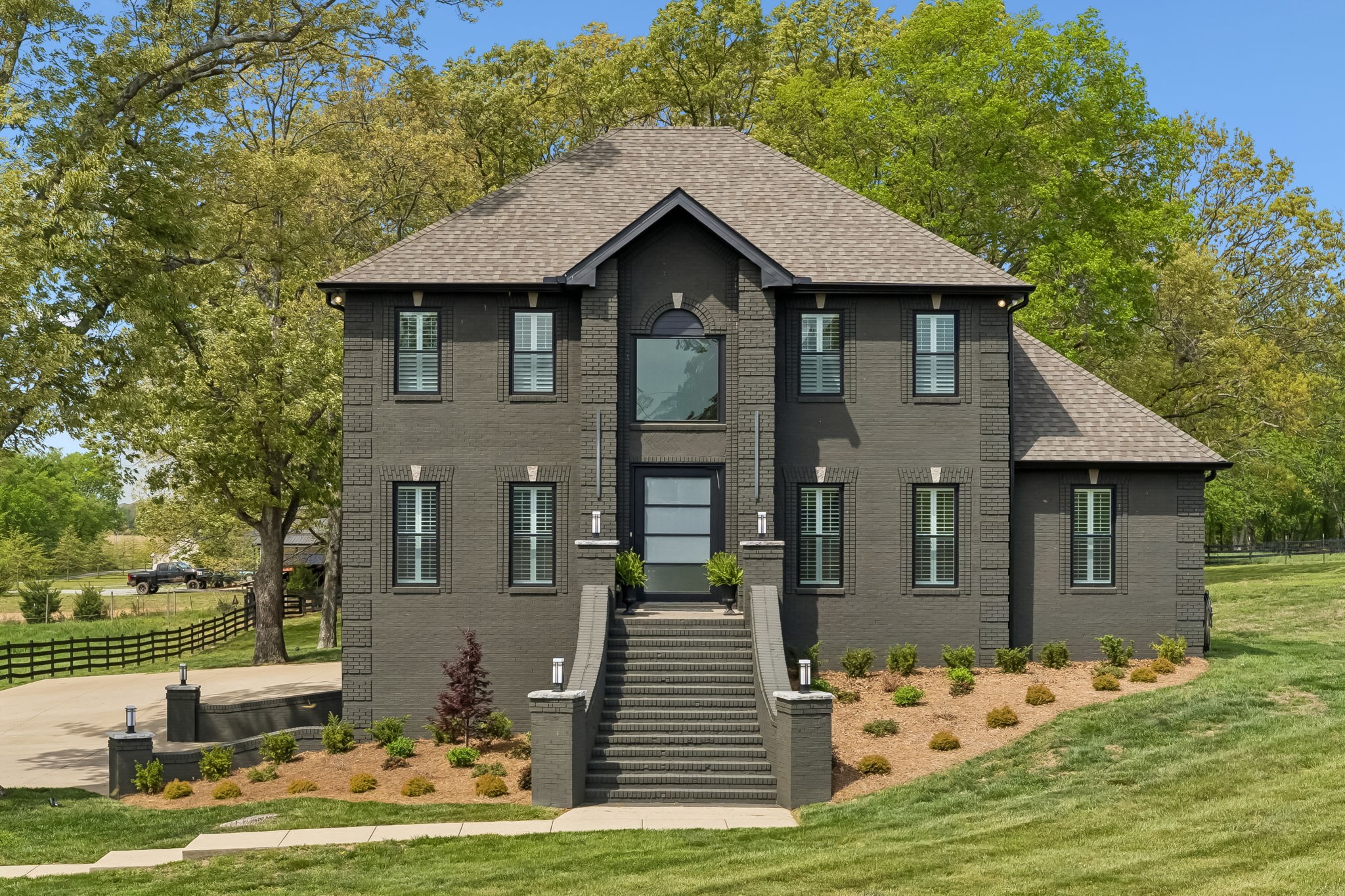 Tucked away on over 26 private acres, this fully renovated estate offers a rare blend of elevated design, thoughtful functionality, and peaceful country living. The setting speaks for itself with rolling pastures, mature trees, plank fencing, and picturesque ponds. Inside, the home has been extensively remodeled with over $400,000 in upgrades. Refinished oak hardwood floors, new windows with plantation shutters, a newer roof, fresh exterior paint, and a striking 5x8 pivot iron front door set the tone throughout.The kitchen is designed for both everyday living and entertaining, featuring custom cabinetry with illuminated glass uppers, granite countertops, dual farmhouse sinks, KitchenAid appliances including a gas range with double ovens, and an oversized peninsula with seating. A room-sized butler’s pantry offers extensive cabinetry and prep space. The main living area is open and inviting with finishes and a custom staircase. The main level primary suite offers a spa-inspired bath with marbled tile, dual vanities, a soaking tub, and tiled shower, along with a generous walk-in closet. Upstairs offers a large bonus space with surround sound, wet bar, and access to the deck, along with generously sized bedrooms including a secondary suite and Jack-and-Jill layout.The 5-car garage with workshop space with HVAC, hot/cold water, and floor drains, and a storm shelter provide endless possibility. The property is fully fenced and cross-fenced with a cattle lane, loading chute, and holding pen, ideal for a turnkey livestock setup if desired. Positioned near I-65 for ease of access, this home offers the perfect balance of private, refined living and everyday convenience. Incudes tax Parcel ID: 037  030.00 and   037 031.00.