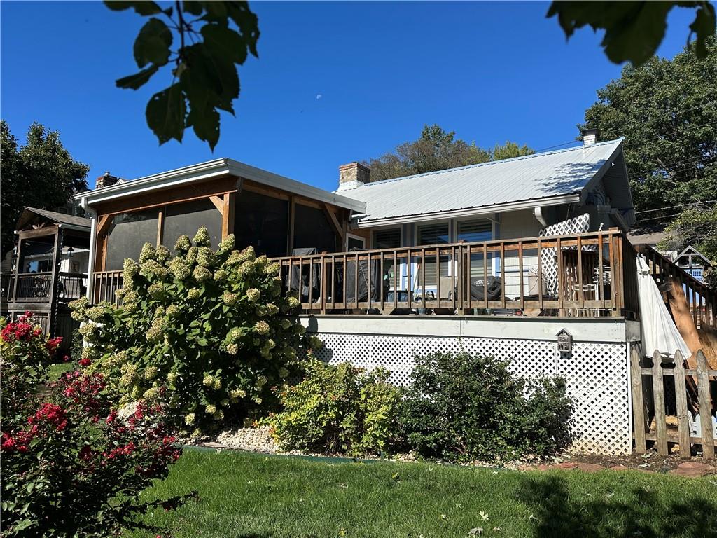 Welcome to this quaint and inviting lakefront home on beautiful Lake Tapawingo, where timeless charm and relaxed lake living come together. From the moment you enter, you’ll appreciate the warmth and character of this special home.The beautiful eat-in kitchen is designed for gathering, featuring a large center island and plenty of space for family and friends to enjoy meals together.  Seller recently installed a new gas stove, dishwasher, and trash compactor.  The adjoining great room is truly the heart of the home, highlighted by a gorgeous floor-to-ceiling stone fireplace that creates a cozy focal point and adds to the home’s distinctive lake-house character.A bright and welcoming sunroom provides the perfect spot to enjoy your morning coffee, read a book, or simply take in the peaceful surroundings. Step outside to the screened deck, where you can relax and enjoy the lake breeze while entertaining or unwinding at the end of the day.The home’s charm continues upstairs with a second bedroom tucked into the loft, offering a cozy and private space for family or guests.Whether you’re looking for a weekend getaway, a full-time residence, or a place to create generations of lake memories, this charming Lake Tapawingo lakefront home offers the relaxed, welcoming lifestyle that makes lake living so special.  A dock and boat lift completes this package.