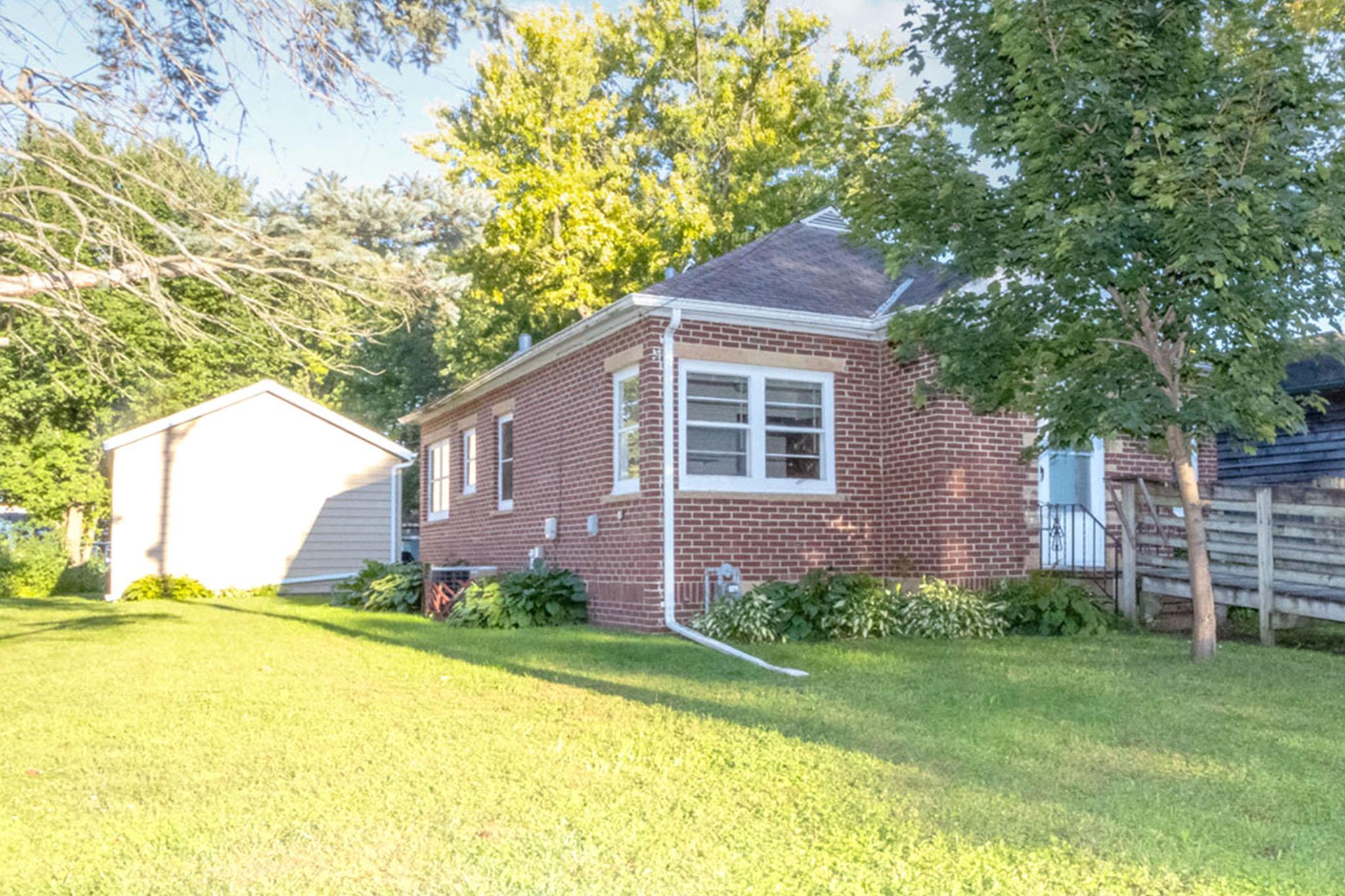 Charming 1.5-story brick home with a handicap-accessible entry and bath, plus laundry available on both the main and lower levels for extra convenience. The bright living room and eat-in kitchen, accented with stone walls, create a warm and welcoming feel. Spacious bedrooms and beautiful hardwood floors add to the home’s character.
Step outside to enjoy the nicely landscaped yard, perfect for curb appeal and outdoor gatherings. The three-season screen porch with slate flooring is an ideal spot to relax. A newer, oversized single garage with high ceilings and plenty of off-street parking adds great functionality.
With a walk-up attic and unfinished basement, there’s lots of space to grow. Located close to Land of Memories Park, this home offers wonderful potential with just a touch of TLC.