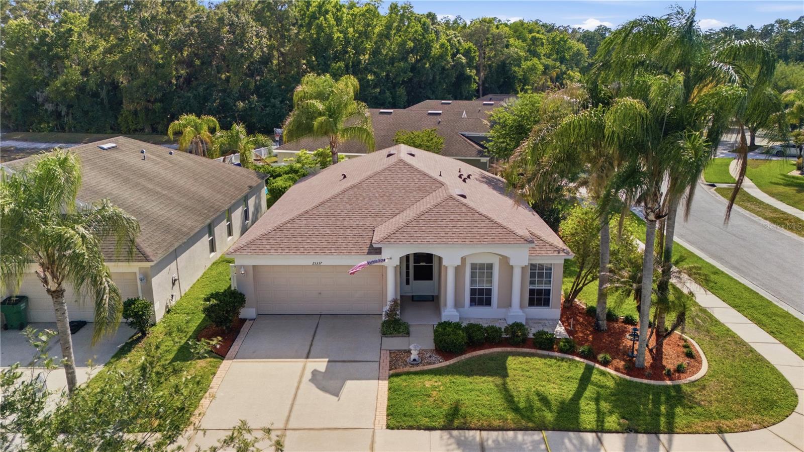 One or more photo(s) has been virtually staged. Located in the highly desirable Lexington Oaks community, on a CORNER LOT this well-maintained 1,525 SF, split-floorplan home offers 3 bedrooms, 2 bathrooms, and a thoughtfully designed open layout ideal for both everyday living and entertaining. The secondary bedrooms and guest bath are positioned toward the front of the home, providing privacy and separation from the spacious primary suite tucked away in the rear of the property. The expansive living and dining areas seamlessly connect to a bright and functional kitchen featuring ample cabinetry, pantry storage, and a casual dining area perfect for morning coffee or informal meals. Sliding glass doors open to a screened lanai and private backyard, creating a comfortable indoor-outdoor living space ideal for relaxing or hosting guests. Additional highlights include a practical layout with the garage conveniently located to the left of the front entry, generous natural light throughout, and a welcoming atmosphere that feels both open and inviting. Major updates include: Roof (2023), HVAC (2017), Water Heater (2014), and Screen Enclosure (2003). Situated within the amenity-rich Lexington Oaks community, residents enjoy access to golf, a community pool, fitness center, tennis, basketball courts, playgrounds, and scenic walking trails, all conveniently located near I-75, shopping, dining, hospitals, and top Wesley Chapel destinations.