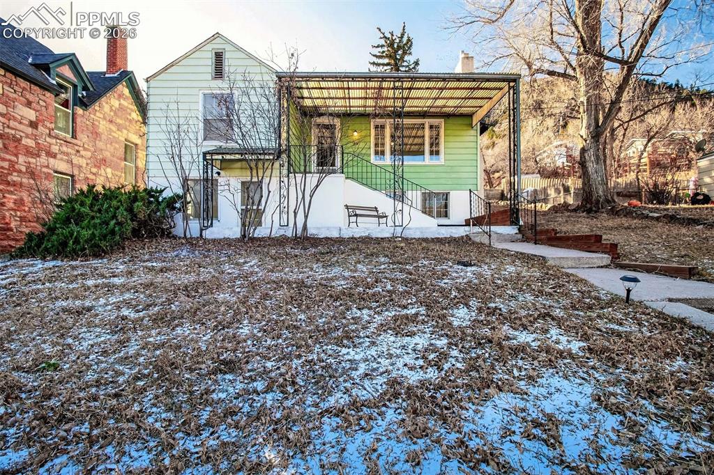 WELCOME HOME to a true unicorn property in the heart of the Manitou Springs Historic District, offering rare land, versatility, and lifestyle just minutes from downtown. Perched at the top of a hill, this exceptional property enjoys incredible mountain, city, and rock formation views, creating a daily backdrop that feels both private and awe-inspiring. Set on over .38 acres across three separate lots, opportunities like this are rarely found in Manitou Springs. Start your mornings sipping coffee while soaking in the panoramic views from nearly every angle. The main residence sits on a sizable lot and has been thoughtfully renovated, featuring new LVP flooring floating over original wood floors, fresh interior paint, refreshed kitchen with stainless steel appliances, updated main level beds/bath, ceiling fans, and upgraded fixtures. The home offers 3 bedrooms, 2 baths, full attic storage with pull-down ladder, and a custom ADA ramp for accessibility. The walk-out basement has its own separate entrance, newer porcelain tile flooring, gas plumbing, laundry, and previously housed a kitchenette (refrigerator still there), making it ideal for conversion to an ADU, duplex, or multigenerational living space, if desired. Lot 2 includes an oversized detached garage with workshop space, a separate lockable storage/office area, and a large storage shed with utilities. This parcel also features a built-in outdoor entertaining area with patio, fire pit, grill, seating area, and picnic table perfect for enjoying sunset views and gatherings under the mountain sky. Lot 3 is flat & buildable, located where the road dead-ends into the property, offering exceptional privacy & future potential. Dual street access and abundant parking add even more value. Properties offering multiple buildable parcels, separate living potential, oversized garage/workshop, and true views are exceptionally rare. Don't miss your chance to own this incredible home in the heart of charming & historic Manitou!