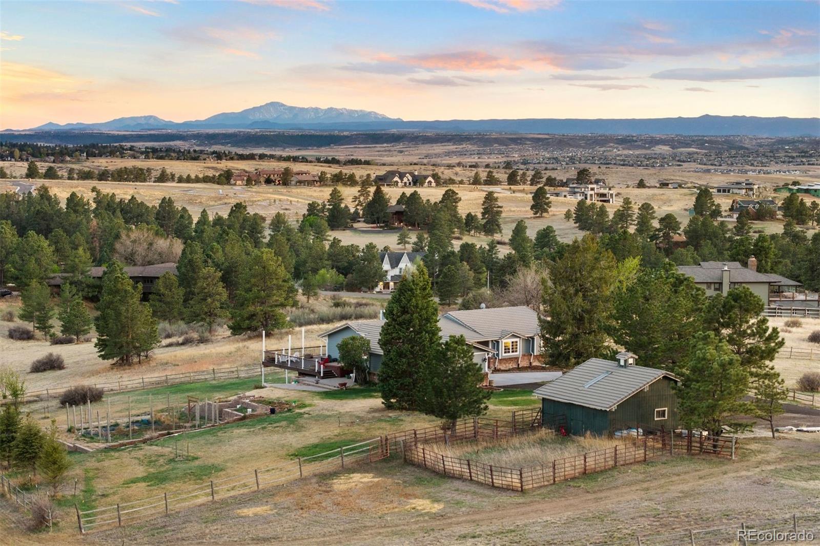 Wake up to sunrise along the Front Range; unwind watching sunset illuminate Pikes Peak from your expansive wrap-around deck. Tall pines, crisp air and QUIET host this beautifully renovated ranch home on 5 acres in Butterfield. Step through the front door and you're immediately home—wood-burning fireplace, natural oak hardwood floors, picture-perfect views. From the great room, the dining room opens to the remodeled kitchen with gas cook top, new appliances, and walk-in pantry. Down the hall you’ll find designer finishes and gorgeous alder woodwork framing peaceful views. The spacious primary suite offers a private deck, abundant walk-in closet, and spa-like bathroom with multi-head walk-in shower, heated tile floor, and soaking tub with sweeping mountain views. A second bedroom offers a charming built-in window bench and beautiful natural light. Granite and marble countertops and Alpen windows in the bedrooms elevate everyday living. Downstairs, a new-construction walk-out basement feels like a home within a home: expansive family room with gas fireplace, stunning kitchenette with quartz counters and walk-in pantry, two bedrooms, an office ready to be a 5th bedroom, two bathrooms and heated floors, and new WeatherShield windows throughout.  Movie nights for everyone or family moving closer? This level delivers. Outside, you're home on the range in the best way. Deer and antelope wander the neighborhood, but your irrigated garden is protected by an 8-foot fence. Unwind in the Wind River hot tub or gather on the lower paver patio. A 4 stall barn with tack room, power and water, and fully fenced property welcomes horses! The entire 5 acres are enclosed with a buried electric dog fence. Tucked into a quiet neighborhood, minutes to Colorado Golf Club and Parker's vibrant shopping, dining, and entertainment, every morning is simply you and nature’s beauty. This is the one you’ll want to call home. For all the details on this beautiful and worry-free home, reach out today!