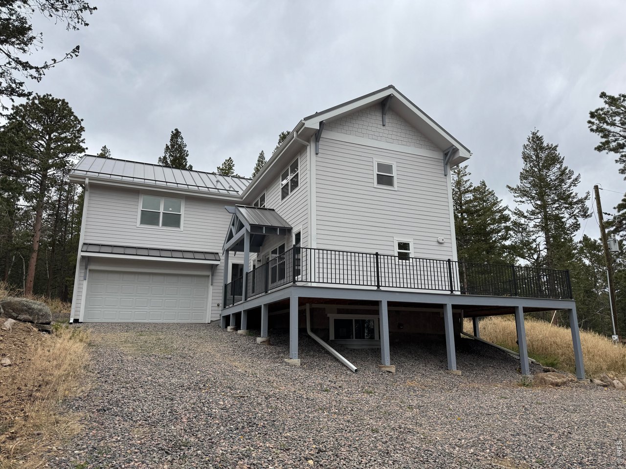 Come live your best live in a newly built beautiful home in popular Bar K Ranch with school bus service at the entrance to the neighborhood. The 3 bed, 2.5 bath home offers a modern synergy of a mountain chalet with the benefits of a contemporary home. Enjoy your own slice of heaven and serenity on almost an acre (.95) of privacy. Surrounded by beautiful trees you feel like you are in a tree house as you look out the sliding glass doors from the living room or when sitting on the large Trex wrap around deck accessible from 3 different doors. These doors and windows create a light and bright interior which features an open floorplan and gleaming wood floors on the main floor that seamlessly connect the kitchen with island, dining and living rooms. Upstairs offers a spacious primary bed, 5 piece bath, and his and her walk-in closets with the tree house views, 2 more bedrooms with a shared bath and an oversized laundry room complete with a sink and cabinets for storage for convenience. Also features a covered entry, quartz countertops throughout, and central a/c. This home has a metal roof and is HERS rated creating an energy-efficient lifestyle as well as built to Boulder County's building code and current fire mitigation practices. Bar K Ranch is a voluntary HOA and is renowned for its multiple fishing ponds, natural beauty, hiking and horse trails, community stable and garden, and proximity to outdoor recreational opportunities. Certificate of Occupancy in hand. New septic which does not require Septic Smart Certification. Buyer responsible for appliances and primary bath shower door and is priced accordingly. Welcome home, just in time before the snow starts and the holidays!!!