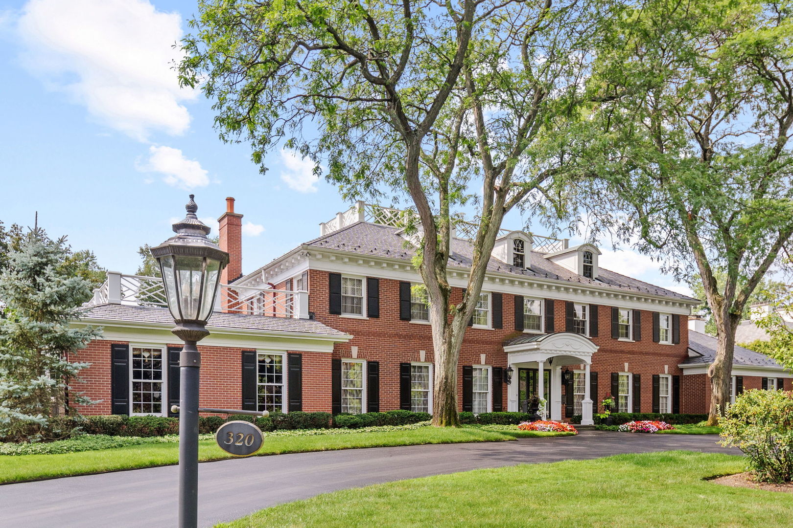Perfectly nestled on one of Winnetka's finest enclaves, this stately 6-bedroom, 5.2-bath Georgian estate offers a rare fusion of architectural elegance, exceptional craftsmanship, and resort-style amenities. Set on nearly an acre of meticulously manicured grounds, the estate is introduced by a sweeping circular drive that highlights the home's classic brick facade, brand-new DaVinci slate roof, columned portico, and timeless symmetry. Together, these elements create a striking first impression and set the stage for interiors that exude sophistication at every turn. Step inside the grand "bookmatched" marble-floored foyer, where a dramatic staircase sets a refined tone for the home. To one side, the formal living room offers an inviting gathering space anchored by a marble fireplace, while the formal dining room is perfectly scaled for both intimate dinners and large-scale entertaining. A massive, richly paneled home office with dramatic coffered ceilings offers an impressive and inspiring workspace.    At the heart of the home, the gourmet kitchen boasts professional-grade appliances, an oversized island, full wall of pantry storage, and a sunlit breakfast area all overlooking the magnificent pool and grounds. A butler's pantry ideally placed between the kitchen and dining room provides effortless entertaining. Just beyond, the kitchen opens to a cozy family room with a fireplace and wet bar, while French doors lead to an expansive covered terrace framed by graceful curved archways and cooled by ceiling fans. This spectacular outdoor living space features a brand-new outdoor kitchen fully equipped for grilling and al fresco dining, leading to the sparkling pool, surrounding patio and yard, creating a seamless setting for summer entertaining and secluded relaxation. A convenient first-floor laundry/mud room right off the 3-car heated garage with epoxy flooring and 2 powder rooms adds everyday ease. Upstairs, the elegantly appointed primary suite offers dual walk-in closets, a dedicated vanity area, and a spa-inspired bath with separate vanities and radiant heated floors. Four well-proportioned additional bedrooms, each with generous closets and either en-suite or adjoining baths, provide comfortable accommodations for family and guests. This level is further enhanced by expansive linen closets, abundant storage, and a dedicated luggage room. The impeccably finished lower-level rivals any private club, featuring a state-of-the-art home theatre, richly paneled billiards and game room, fully outfitted bar, expansive fitness studio, wine cellar, guest suite, and a dedicated woodshop for refined hobbyists or craftsmen. Located in one of Winnetka's most prestigious locations and served by its award-winning schools, this remarkable estate perfectly balances classic sophistication with modern luxury. Combining architectural pedigree, unparalleled amenities, and impeccably landscaped grounds, this is a home to be cherished for generations. Furniture available for sale.