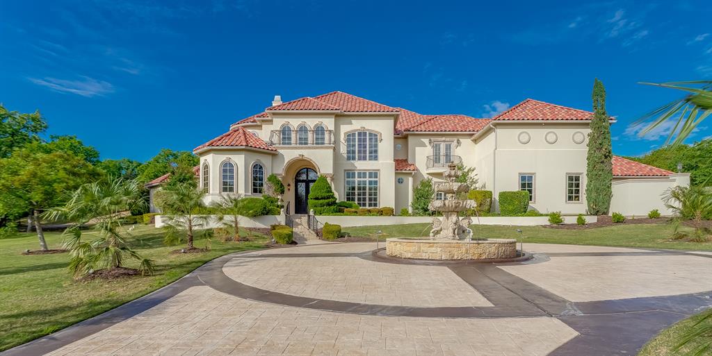 A stunning Mediterranean estate designed for those who love to entertain and live exceptionally well, this 7,499 square foot residence sits on 1.82 acres in a cul-de-sac on the golf course within the prestigious Estates at Tour 18, a 24-7 guarded and gated community. From the moment you step inside, soaring 25-foot ceilings create a dramatic and inviting presence, setting the tone for a home that is both grand and welcoming. Designed for hosting on any scale, the home features a dedicated media room, an large game room with kitchenette, and seamless indoor-outdoor living. The resort-style backyard offers a sports court, pool, and an impressive gas firepit, making it the perfect setting for unforgettable gatherings. At the heart of the home, the oversized kitchen is as functional as it is beautiful, featuring dual dishwashers, a vegetable sink, and striking lighted Cristallo countertops. Around the corner, a built-in desk area provides space for homework or everyday organization. The secluded master suite is a true retreat, complete with a sitting area. A versatile bonus room with a closet, ideal for a nursery, private office, craft room, or additional storage is nearby. The spa-like master bath offers a steam shower, rain head, and a towel warmer for a true luxury experience. Three additional bedrooms are upstairs, including one with its own balcony. A separate guest house offers comfort for extended stays or multigenerational living. Every detail has been carefully chosen, from marble countertops in all bathrooms to a central vac system, electronic window treatments, and chandeliers that lower electronically for easy maintenance. Set within one of the area’s most sought-after gated communities with scenic golf course views, this home offers a rare combination of privacy, scale, and elevated living. You can keep searching… but you won’t find another one like this. Many furnishings in the home are available for purchase.