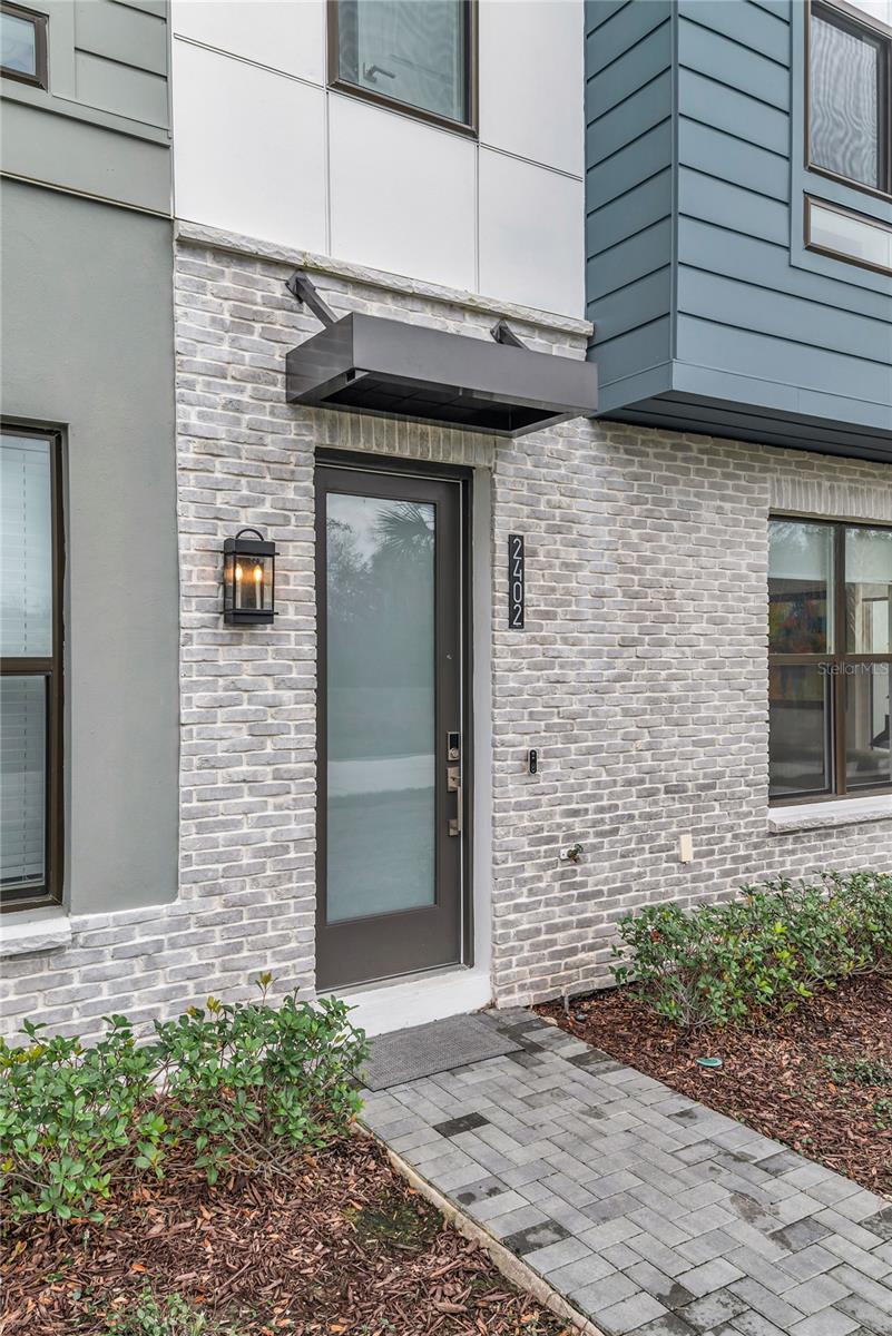 Arguably the best opportunity to come to market in The Brix, this better-than-new corner luxury residence offers a rare 4-bedroom floor plan in one of the most desirable positions within the community.Built by Toll Brothers, the sought-after Nova Modern Elite II model spans four levels of thoughtfully designed living space, showcasing elevated architecture and curated, high-end finishes throughout. The corner orientation provides exceptional privacy while flooding the home with natural light, creating a bright, open, and airy feel rarely found in townhome living.Perfectly positioned to capture sweeping water and conservation views, the home is ideally oriented for evening sunsets and offers direct access to miles of walking and biking trails maintained by the City of Orlando.One of the defining features is the expansive rooftop terrace—prepped for a future four-season outdoor kitchen, fireplace, and hot tub—creating a true extension of the living space and one of the most compelling entertaining settings in the community.Additional highlights include whole-home Wi-Fi integration and a central vacuum system across all levels, further enhancing everyday comfort and convenience.Located within The Brix in the heart of The Packing District, this residence offers immediate access to one of Central Florida’s most dynamic and thoughtfully planned developments. Residents enjoy proximity to a 33,000 sq ft YMCA, Orlando Tennis Center, amphitheater, Foxtail Coffee, Publix, Southern Box Food Hall, 4Roots Farm, extensive green space, and more—delivering a true live-work-play lifestyle just minutes from College Park and Downtown Orlando.With its combination of rare bedroom count, premium positioning, and elevated finishes, this is one of the most compelling offerings to hit The Brix in some time