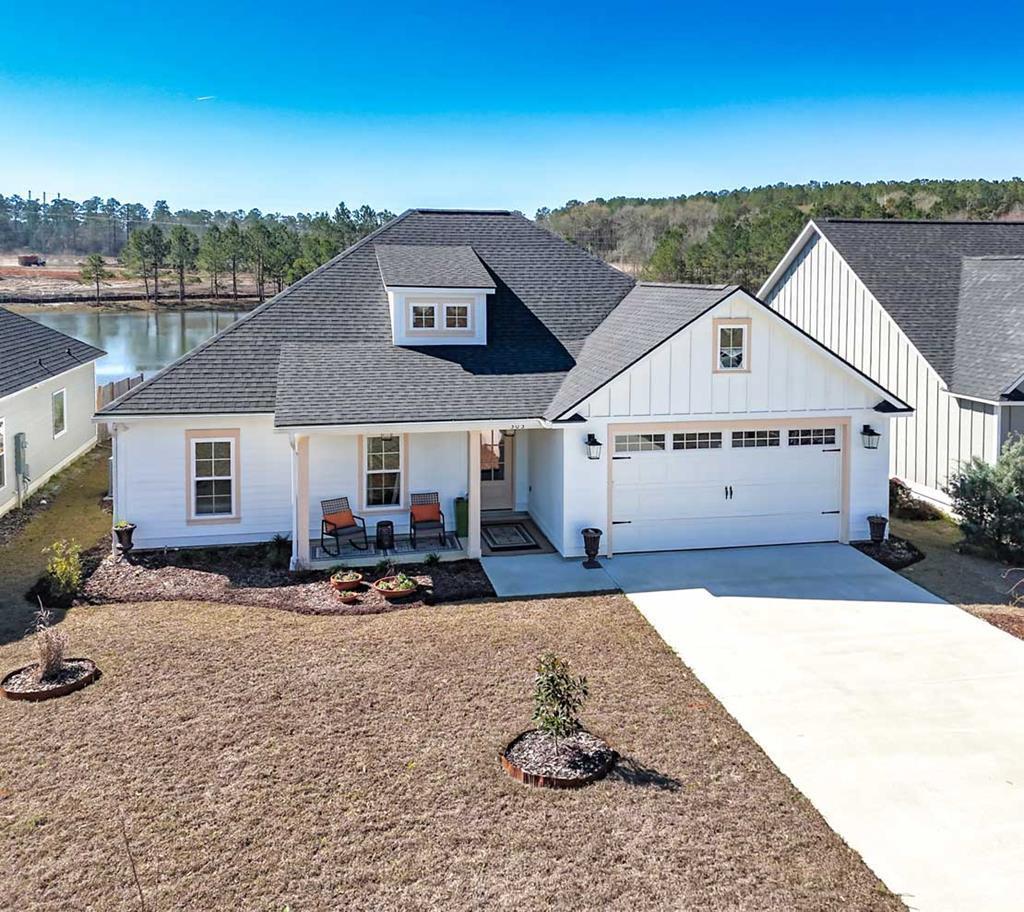 Practically new waterfront home in Thomasville, GA offering exclusive fishing privileges and stunning lake views. This move-in ready property combines comfort, style, and peaceful lakefront living. Enjoy exceptional outdoor spaces including a custom back patio with Mexican tile, roll-out sunshade, and covered porch, along with a spacious covered front porch and a beautifully landscaped yard featuring custom flower beds added by the seller. The home features low-maintenance HardiBoard exterior siding, fresh exterior paint, and an inviting open-concept layout with vinyl plank flooring, custom lighting, and abundant natural light throughout.  The kitchen is designed for both function and entertaining, featuring granite countertops, a large island with bar seating, pantry, pot filler, and seamless flow into the living and dining areas highlighted by a coffered ceiling. A breakfast area overlooks the lake, while the spacious living room showcases large windows with serene water views. The luxurious owner's suite includes a sitting area and beautiful lake views, along with a spa-inspired bathroom featuring a walk-in shower, soaking tub, dual vanities, and an oversized walk-in closet with ample storage.  Additional living space includes three generously sized bedrooms and a shared full bathroom, making the home ideal for family or guests. Custom upgrades throughout include window blinds, upgraded lighting, and thoughtful finishes added by the seller. Practical features include a large laundry room with coat area, a two-car garage with a built-in storage system, and abundant storage throughout the home.  Enjoy true waterfront living where you can fish from your own property or simply relax and take in the peaceful lake views. This exceptional Thomasville, GA home is truly turnkey and ready for its next owner to enjoy lakefront living at its finest.