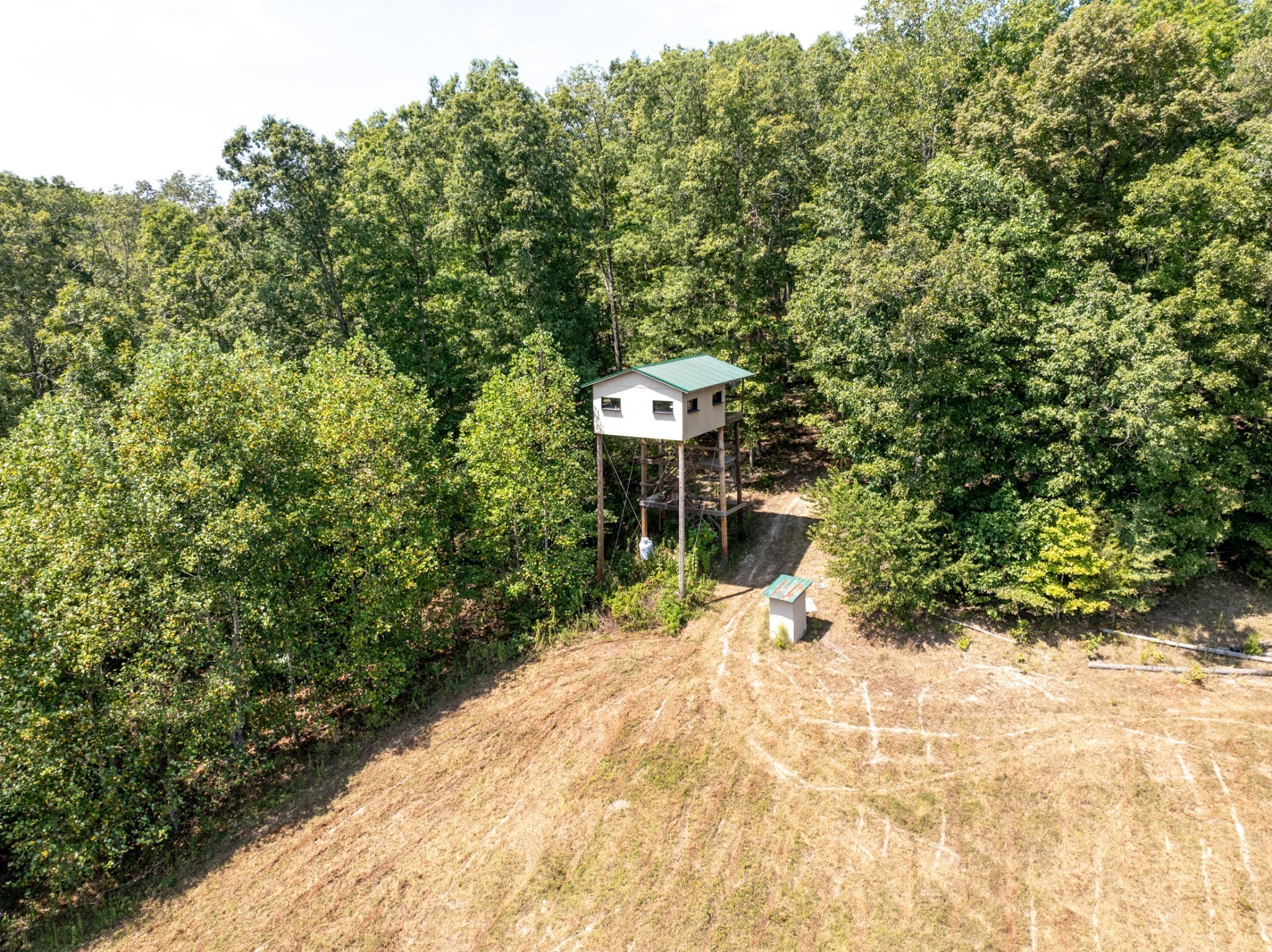 Private 104-acre Tennessee retreat offering the perfect blend of recreation, farming, and peaceful country living! Rolling hills, mature timber, open pasture, a stocked pond, abundant deer and turkey, and an impressive 16x16 elevated hunting cabin make this property truly one of a kind. A picturesque entrance and long concrete drive lead to a timeless home tucked away in complete privacy. Inside you'll find hardwood floors, fresh paint, a grand staircase, 3 fireplaces, custom built-ins, granite countertops, newer appliances, and a formal dining room with fireplace. Relax on the spacious covered porches overlooking this beautiful property. New roof in 2025! Additional features include a detached 2-car garage, whole-house generator, Apollo 100-gallon water tank, MLConnect Fiber Internet, and a partially finished basement with workshop, gun room, hobby room, full bath, and abundant storage. Whether you're looking for a forever home, hunting retreat, working farm, or legacy property, this rare offering is full of opportunity. Seller will consider selling the home with approximately 5-15 acres separately. Sellers would be willing to sell home separately with approx 5-15 acres. See MLS#3319284
