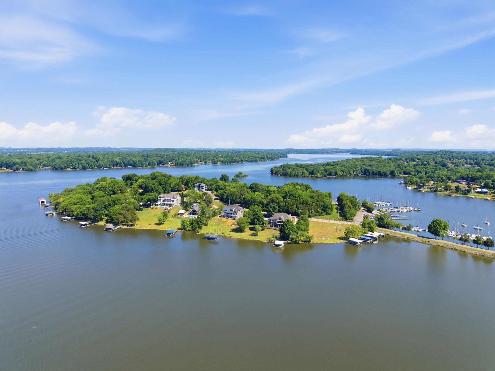 Experience a rare opportunity to own a three-level estate on the region's only private island. This gated lakefront sanctuary on Old Hickory Lake offers unparalleled exclusivity with a front row seat to a thriving natural ecosystem, including a Great Blue Heron rookery, bald eagles, ospreys and more. The property features a coveted grandfathered in dock and sits moments from the yacht club, with waters stocked with bass, crappie, walleye, and bream. Enjoy permanent privacy as the neighboring lot is HOA owned and designated as "never-to-be-built-on." This home features a primary suite on the main floor and a complete first floor in-law apartment with two bedrooms, two bathrooms, a full kitchen, and private laundry. Combining security with the serenity of island life, this is a truly irreplaceable lakefront setting.