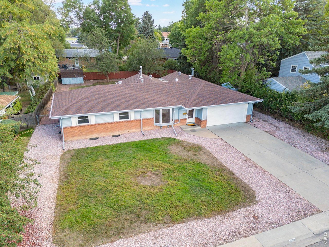 University Acres is one of Ft. Collins' most established and sought-after neighborhoods, known for its mature trees, spacious lots, large and distinctive mid-century homes, and unbeatable central location. Residents enjoy quiet streets, excellent walkability and bikeability, and convenient access to Colorado State University, Spring Creek Trail, Poudre Valley Hospital, and Old Town, offering timeless character with everyday convenience. Situated on a shady 1/4-acre lot with mature trees and established landscaping, this ranch-style home with a finished basement offers exceptional space and endless potential. The main level features nearly 1,650 square feet of living space, including original hardwood floors in the living room and all three bedrooms. The kitchen and dining area flow into an expansive 20' x 24' family / dining room that serves as an outstanding place to entertain, highlighted by a corner wood-burning fireplace with a beautiful stone surround. Just off the family room, a bright three-season sunroom provides the perfect place to relax while overlooking the private backyard, with direct access to the patio. A second exterior door off the kitchen offers convenient access to the backyard and an oversized storage shed. In the basement you'll find a spacious third living area, two additional non-conforming bedrooms, a bathroom with a walk-in shower, and a large utility, laundry, and storage room. The basement provides flexibility for guests, hobbies, or a home office. Major system updates include a new furnace (2019), new electrical breaker panel (2019), and new water heater (2022). This is an outstanding opportunity to own a home in one of Fort Collins' most cherished neighborhoods at an affordable price point. Move in and update over time while building equity, or join many of your neighbors and reimagine the space to create your dream home in a location that continues to be one of the city's most desirable.