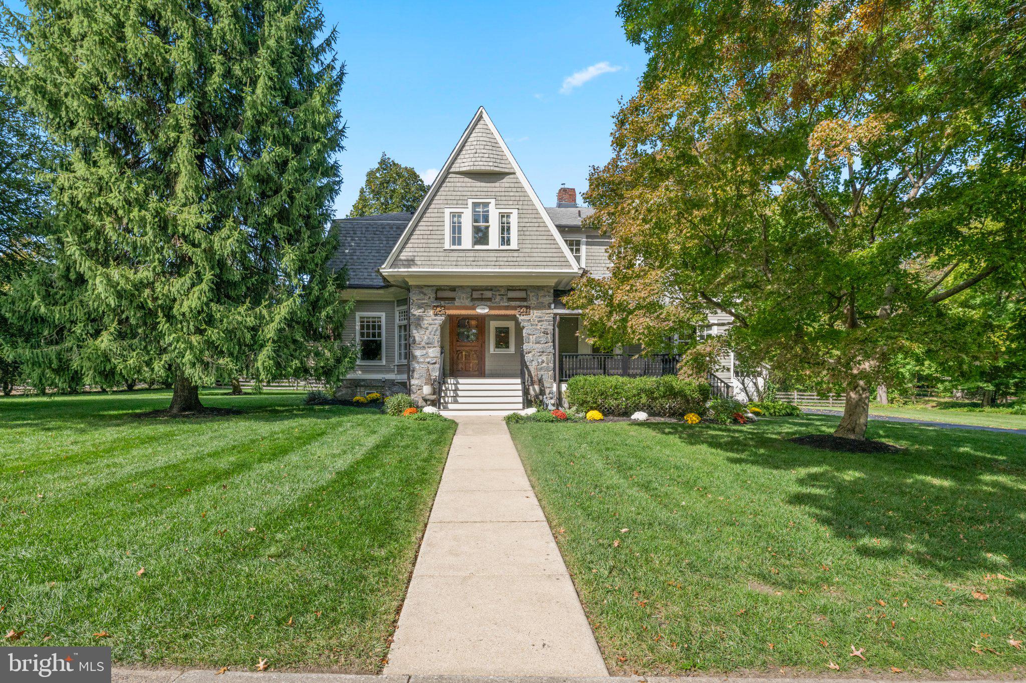 Just two blocks from downtown Wayne, this beautifully updated Victorian seamlessly marries architectural character with modern features—all on a sprawling, tree-lined corner lot. The current owners completed an exceptional renovation that expanded the original footprint while honoring the home’s historic roots—earning it a prestigious Radnor Historic Preservation Award. A distinctive stone archway artfully frames the entry and front porch, which offers an inviting spot to relax, visit with neighbors and enjoy the surroundings. Step inside to a gracious, light-filled foyer, where intricate moldings and millwork, gleaming hardwood floors and newer paint set the tone for the beautifully appointed spaces to follow. Just off the foyer, enjoy a spacious, sun-drenched living room while the adjacent dining room offers an elegant yet comfortable setting for both intimate dinners and larger gatherings. Continue down the hall to the true heart of the home—a spectacular kitchen-great room designed for effortless living and entertaining. The expansive chef’s kitchen is outfitted with high-end appliances—including a six-burner Wolf® range and oversize Subzero® refrigerator—along with custom curved island, farmhouse sink, abundant cabinetry and walk-in pantry. The family room beyond provides ample space to host and unwind with French doors opening to the backyard. An adjacent mudroom keeps everyday essentials organized and out of sight. Other main floor highlights include a window-lined front office, stylish powder room with exposed brick, laundry room, butler’s pantry with glass-front cabinetry and convenient secondary rear staircase. Take the gorgeous main staircase upstairs, where you’ll find a showstopping primary suite (part of the award-winning renovation!) with vaulted ceiling, dual walk-in closets and ensuite full bath with glass shower. An adjoining sun porch offers a delightful private retreat. Four additional bedrooms provide exceptional flexibility for family and guests: one features an ensuite full bath while another enjoys direct access to a second sun porch. A full hall bath completes this level. Outside, the property boasts one of North Wayne’s best lots with expansive flat greenspace, mature trees and landscaping. A detached two-car garage, newly repaved driveway, newer HVAC and tankless water heater offer convenience and peace of mind. Enjoy all this mere steps from downtown Wayne’s popular restaurants, cafés, shops and commuter rail, along with nearby parks and playgrounds. Located within award-winning Radnor Township School District, this home is also part of the North Wayne Protective Association, a beloved group known for neighborhood events and family-friendly traditions like block parties, progressive dinners and holiday caroling. Don’t miss this rare opportunity to own a piece of North Wayne.