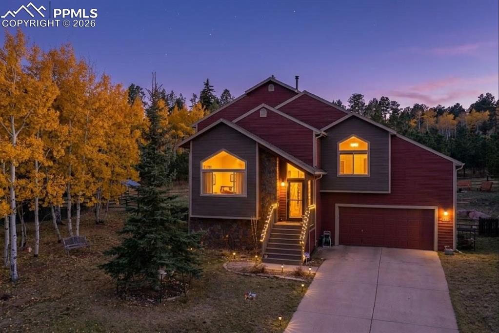 Discover the perfect blend of modern efficiency and mountain charm in this meticulously renovated 2,602 sq. ft. residence. Nestled on a .38-acre lot that backs to a serene wooded area, this home offers a private sanctuary within walking distance of downtown Woodland Park.The main level boasts a bright foyer with vaulted ceilings leading into an expansive living area. A rebuilt two-way fireplace serves as a stunning focal point between the living room and the kitchen/sitting area. The redesigned kitchen features engineered hickory floors, newer countertops, a natural tile backsplash, and upgraded cabinetry with under-counter and over-cabinet lighting.The upper level primary suite is a true escape with vaulted ceilings, a walk-in closet with custom organizers, and a master bath featuring dual vanities. Two additional bedrooms with vaulted ceilings share a renovated full bath with ceramic finishes and wainscoting.The flexible lower level space includes a garden-level family room, office, an exercise room, and a 3/4 bath. All perfect for hobbies or guests.The 2-car garage is maximized with overhead racks and a utility sink.The backyard is an entertainer's dream, featuring a brick paver patio with a massive pergola, a custom firepit with oversized wooden benches, and professionally installed drip irrigation for low-maintenance flowering beds. Enjoy the durability of Trex decking on both the front porch and rear deck (rebuilt 2022-2025).Up Grades: New roof (2019), energy-efficient window glazing, whole-house humidifier, and insulated garage door. Fresh interior/exterior paint, new light fixtures throughout, and lattice protection under decks for wildlife deterrence.This move-in-ready gem combines high-end finishes with the "Mountain Rustic" lifestyle you've been looking for. Schedule your showing today!