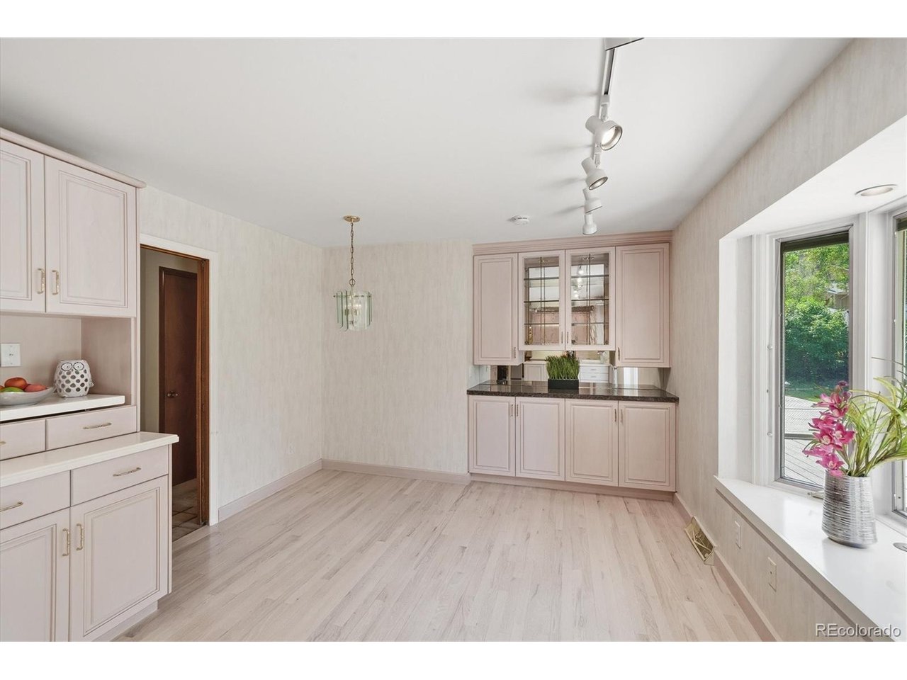 Nestled in one of Littleton's most coveted neighborhoods across from Ridgeview Park & 4 minutes from Heritage High School, this is the kind of home that stops you at the curb and refuses to let go - a beautifully maintained brick ranch radiating pride of ownership, sitting on a rare and generous 1/4 lot that feels like a world apart from the ordinary. Step thru the front door to the warm embrace of hardwood floors pulls you through a thoughtful designed with effortless flow to make everyday living feel quietly luxurious. The heart of the home is a custom kitchen outfitted with beautiful wood cabinetry, crisp white Corian countertops, and a double oven built for those who take their cooking seriously - breakfast nook with built-in shelving just off the kitchen is where morning coffee turns into the best part of the day. Family room, warmed by a crackling fireplace and views of the gorgeous front yard, invites you to stay awhile, while the formal living room stands ready for the moments that call for something more. The primary suite is a private sanctuary with 2 closets plus a versatile storage closet cleverly accessible from both the en-suite three-quarter bath and the hallway bath - a detail that speaks to the home's smart, livable design. Zebra window blinds and plantation style shutters add a touch of flair that carries a relaxed, resort-like energy throughout. Descend to the basement and discover a spectacular rec room anchored by a second fireplace and a sleek floating bar - the ultimate entertaining space - alongside 3/4 bath & 2 non-conforming bedrooms. Outside, a pergola-covered patio overlooks a fully fenced yard while the oversized two-car garage and service door handles everything else. Class 4 roof, newer windows, 2018 furnace, 2018 water heater, water softener, and central AC mean the big-ticket items are already done. West facing garage means easy snow removal! Tennis, park, trails & pickle ball just steps away, this one is special.