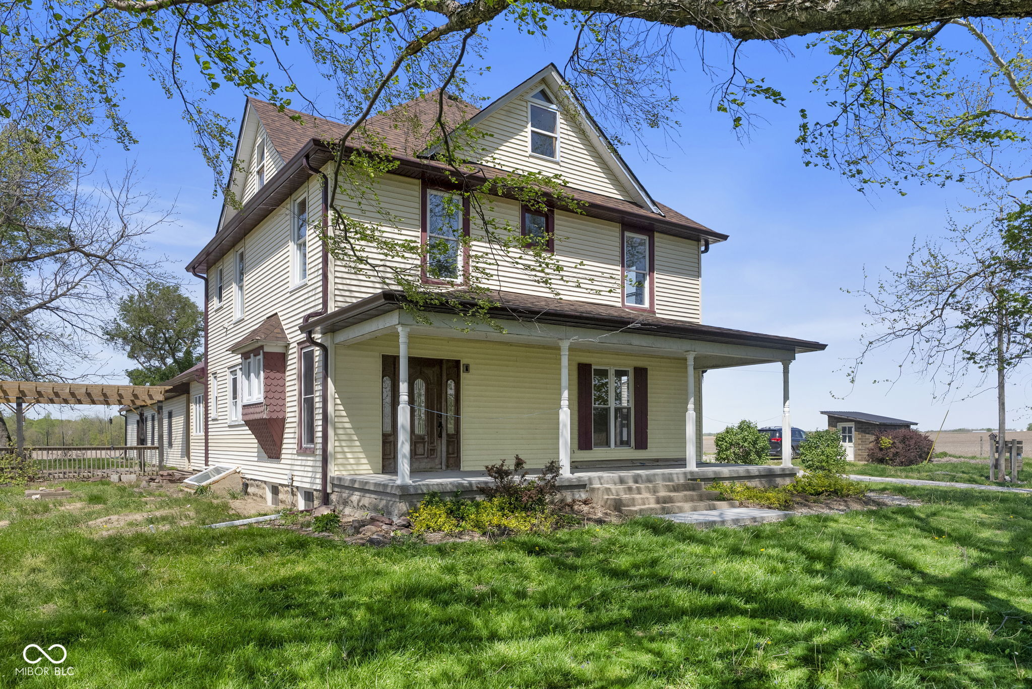 Set on 3.25 picturesque acres off of Highway 59 in Rockville, this stunning 3,040 SF, 2.5 story Victorian farmhouse offers the perfect blend of classic charm, modern updates and incredible functionality...an ideal setting for a mini farm or country retreat!  Step inside to a grand entrance foyer showcasing a striking mosaic tile design inlaid in the hardwood floors, leading to an elegant staircase.  The home features 4 spacious bedrooms and 2 full baths, along with the rare convenience of both a main level laundry room and a second laundry upstairs.  2 cozy gas fireplaces anchor both the living room and dining room, creating inviting spaces for everyday living and entertaining.  The updated kitchen impresses with granite countertops, stone backsplash and a walk-in pantry, blending style with practicality.  Outdoor living is just as exceptional.  Enjoy the covered front porch with new concrete, or relax by the outdoor fireplace on a brick paver patio beneath a pergola, overlooking wide open views.  The mini farm infrastructure is already in place, including a fenced front pasture, garden area and well house/storage shed with a new well pump just installed in February 2026.  The property also boasts remarkable outbuildings: (1)  A massive 1,920 SF oversized, 4-car detached garage with concrete floor and electric; (2) A 1,728 SF pole barn featuring a 2-car garage bay with concrete and electric, plus a 3-stall area behind it (middle stall with concrete floor), electric and water pump/spigot for easy animal watering; (3) A 432 SF lean-to off the back of the pole barn for additional storage; and, (4) Another 384 SF storage barn on the opposite side yard.  Major updates include a new roof on the home just 6 months ago.  With space to spread out, room for animals and serene country views in every direction, this property offers a rare opportunity to enjoy the rural lifestyle you've been dreaming of.