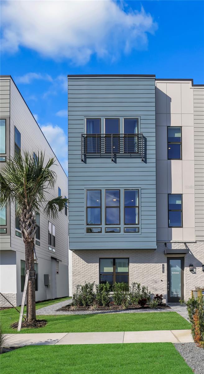 MODEL HOME AVAILABLE FOR SALE! All furniture is included! 
This stunning 4-story townhome is ready for you to move right in and start living the vibrant lifestyle you’ve been dreaming of. Step inside to a welcoming first floor that features a private bedroom with an ensuite bath- perfect for guests, a home office, or multi-generational living — along with a spacious two-car garage for added convenience. The second floor is where life happens. This bright, open-concept space includes a gourmet kitchen with upgraded brown cabinetry that reach to the ceiling, sleek quartz countertops- the island countertop will wow you, a designer backsplash, and premium appliances — refrigerator, range, microwave, dishwasher, washer, and dryer, all included. Enjoy casual meals in the dining area and unwind in the naturally lit great room that’s ideal for relaxing or entertaining. Upstairs on the third floor, you’ll find the serene primary bedroom retreat, a second spacious bedroom, and a walk-in laundry room that adds everyday ease. But the real showstopper? The fourth-floor rooftop terrace — your private outdoor haven, including a summer kitchen, prepped for a future fireplace, and even a hot tub. Whether you’re hosting friends, enjoying a peaceful morning coffee, or catching golden-hour views, this space is designed to impress. Inside, you’ll love the thoughtfully curated finishes: Engineered hardwood stairs and tile flooring throughout main living areas. Want a closer look? Tour our onsite model home, which mirrors the layout and design — and see firsthand why this home stands out. Living in The Packing District means so much more than just having a beautiful home — it’s about embracing a dynamic, connected lifestyle. Start your day with a peaceful walk or bike ride along the scenic 1.5-mile trail, then grab a slice at the food hall or break a sweat at the brand-new YMCA. Meet up with friends for a competitive game of pickleball or tennis at the Orlando Tennis Center — all just steps from your door. And the amenities don’t stop there. The Packing District is growing into one of Orlando’s most exciting new communities, featuring a new Publix, rock climbing facility, Hotworx Studio, and the innovative 4Roots Farm Campus. With future office and retail spaces also in the works, everything you need — from wellness to convenience to recreation — is right at your fingertips.