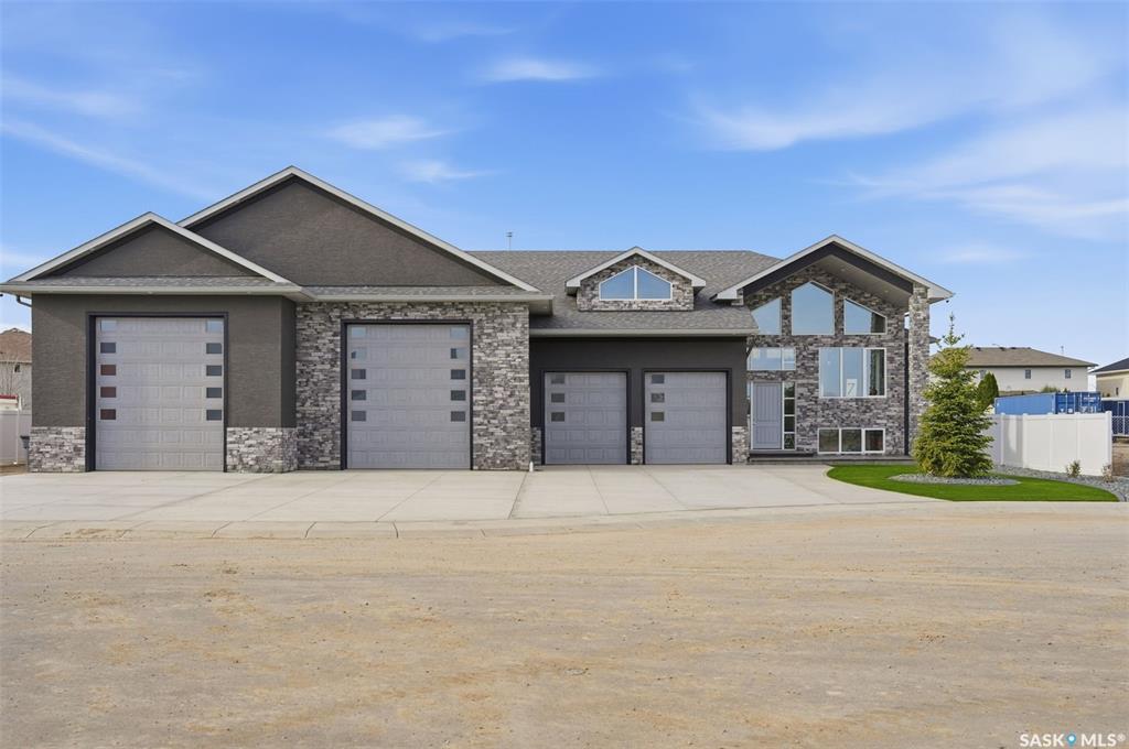 Stunning, one-of-a-kind Executive Bi-level shop/home built with ICF (Insulated Concrete Forms) from floor to roof, situated on a ½ acre lot and featuring an impressive 3,500 sq. ft. attached shop/garage with both in-floor and forced air heat. Designed for ultimate functionality, the shop includes a built-in overhead hoist, 3-piece bathroom, floor drains, 14’ overhead doors, and space to accommodate 20+ vehicles with ample storage.  The home welcomes you with a grand entry and showcases tile flooring throughout the main level, soaring vaulted ceilings, 8-foot doors, and expansive windows bringing in natural light. The kitchen is both elegant and show-stopping, highlighted by a massive 5x10 quartz island, quartz window sills, glass tile backsplash, a 36” dual-fuel gas range, exterior-vented hood fan, reverse osmosis system, central vacuum foot sweeps, & high-end appliances throughout.  The front-facing dining area is perfect for hosting large gatherings, while the living room features a beautiful electric fireplace & provides access to a covered deck and spacious patio overlooking the low-maintenance, gravelled yard with abundant parking. The main floor also includes a 2-piece powder room and a luxurious primary suite complete with a large walk-in closet & a stunning 6-piece ensuite featuring a fully tiled dual shower, soaker tub, in-floor heat, and double vanity. The fully finished basement offers vinyl plank flooring, two additional bedrooms, a 4-piece bathroom, a large games and fitness area, & an impressive theatre/rec room complete with a full wet bar, beverage cooler, theatre-style backlighting, & soundproofing. A spacious laundry room provides additional storage, along with even more space under the stairs.  This exceptional property comes complete with all appliances, central air conditioning, central vacuum, on-demand hot water with recirculation & all window coverings. Zoned for a large home-based business, it offers incredible flexibility & opportunity.