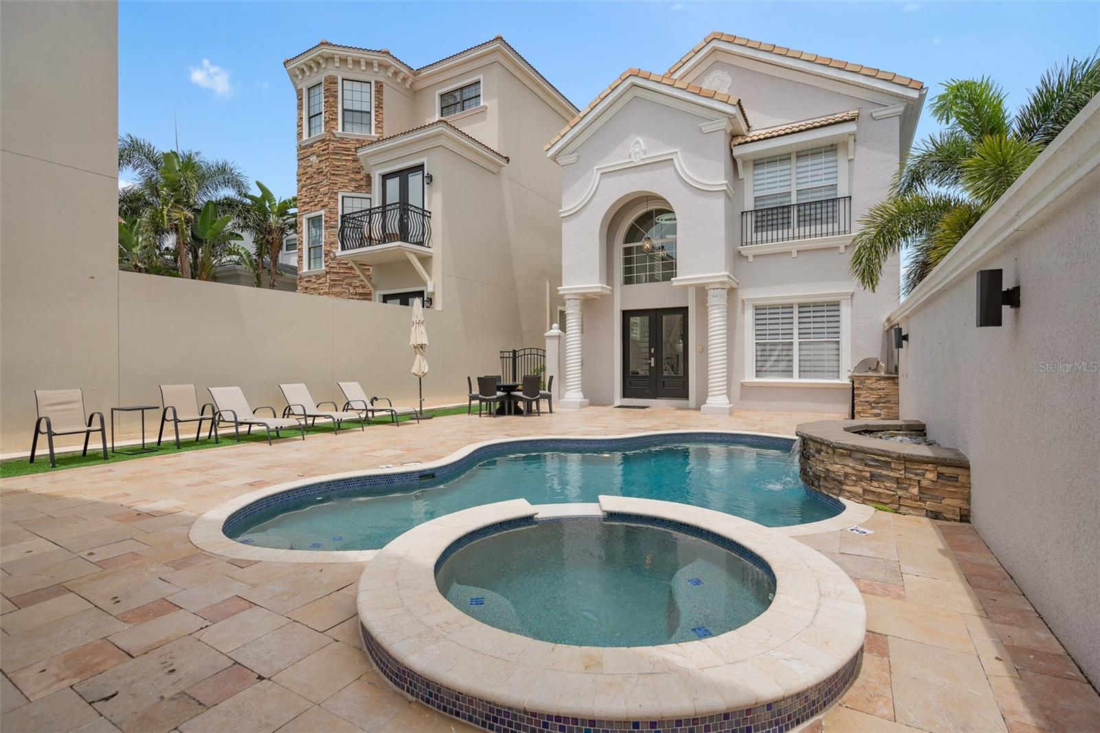 Active Club Membership! Offered fully furnished and turnkey! Positioned along the Arnold Palmer Legacy Golf Course, this 5-bedroom, 4.5-bathroom home offers panoramic water and golf views from multiple vantage points. Located near the center of Reunion Resort, the property provides quick access to the community’s restaurants and signature amenities. At the center of the home is a private courtyard featuring a heated pool, spa, summer kitchen, and outdoor shower. The main entry opens to a two-story foyer that leads to the kitchen, living and dining rooms, a powder room, and one bedroom suite with its own bathroom. Upstairs, the primary suite includes a cathedral ceiling, dual vanity, separate shower, soaking tub, and a private balcony overlooking the golf and water views. A third ensuite bedroom is also upstairs. The detached garage apartment, accessed from the courtyard, includes a kitchenette, two bedrooms, and a shared full bathroom, providing a private retreat. The 2-car garage has been converted into a media and game room, providing an additional 625 square feet of functional living space.Spanning 2,300 acres just 7 miles south of Walt Disney World, Reunion Resort is the only destination in the world featuring 3 signature golf courses designed by Jack Nicklaus, Arnold Palmer and Tom Watson. Reunion is also home to the Leadbetter Golf Academy. Onsite dining options include Eleven, 7593 Chophouse, Traditions, Grande Lobby Sushi Bar, the Clubhouse, the Cove, and Drifters at the waterpark. The water park features a lazy river, slides, outdoor games, and an aquatic playground. The gift shop in the Grande offers sundries and Starbucks coffee. Complimentary shuttles to the Disney transportation and ticket center leave from the Grande daily. Additional amenities include Camp Reunion, the tennis and pickle ball center, bocce ball, miniature golf, foot golf, fitness center, playgrounds, dog park, various community pools including a roof top pool on the 11th floor of the Grande, and more. Zoning for short term rentals allows homeowners to rent their property by the night providing a great opportunity for investors. Reunion also works great as a primary residence or a private vacation retreat. The resort offers three separate 24 hour guard gated entries and one owner/resident only entry.