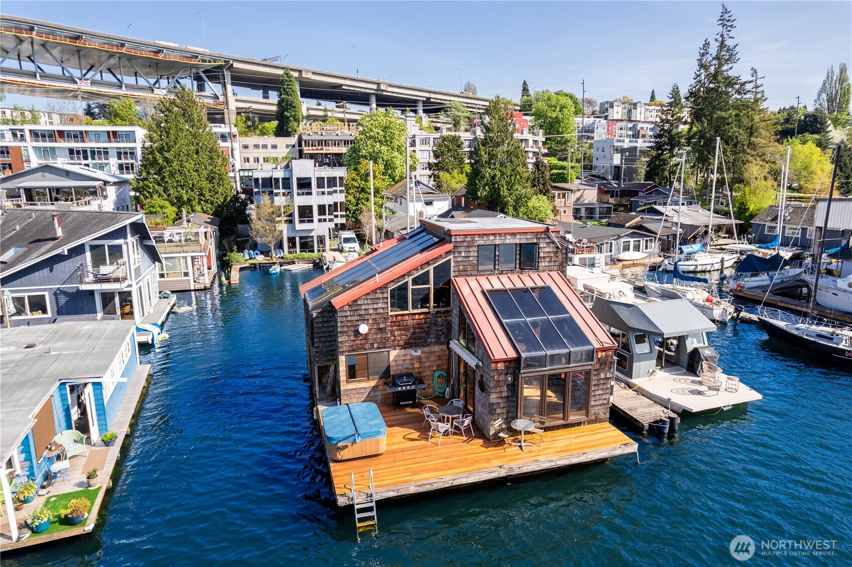 Quite literally the coolest floating home on Lake Union & of course it's end of dock. Condo dock + boat slip & parking. Soaring high above lake w/ views of city, Space Needle & mountains,this one of a kind home by renowned architect Jessup was featured in multiple publications. Lives like a floating treehouse & long admired by the passing boat parade for it's whimsy & beauty. Three bedrooms including primary suite, office/den, & bonus room. Dining room is mid level & a hub, while living room has cozy sunken space for movie night. Deck is newer & you can tie a boat up in front & in private slip behind home + hot tub! Sellers have lived here for many years & recently purchased home's condo slip for $1.5M so that you can own the moorage,too!