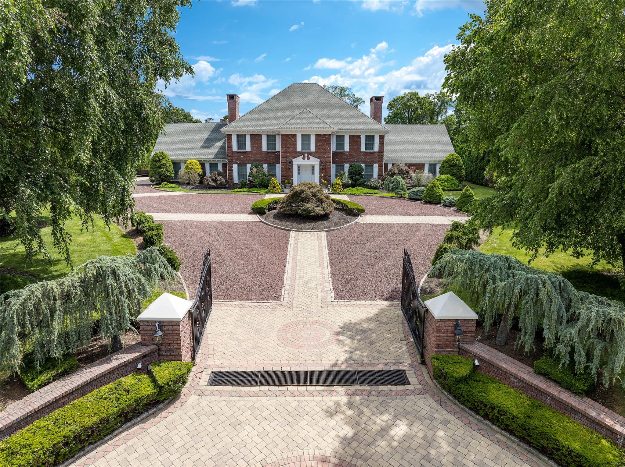 An Iconic Georgian Colonial in Scarsdale’s Estate Section. This residence is more than just a home—it’s a legacy property and a sanctuary for those who appreciate the very best in life! This exceptional estate offers an unparalleled lifestyle with resort-style amenities, timeless elegance and unmatched privacy. This exquisite Brick Georgian Colonial, perched at the highest elevation in Scarsdale, has an abundance of sunlight and total seclusion with a custom electric gate and mature lush specimen trees. This exceptional property is located in prestigious Murray Hill, with top-rated schools, in the wealthiest suburb in the United States.

Built by a renowned builder as his personal residence, no expense was spared in crafting this one-of-a-kind masterpiece. Set on almost 1.5 acres of meticulously landscaped grounds, the property blends Hollywood grandeur with open-concept living, while still honoring traditional elegance with high ceilings, a show-stopping kitchen, dramatic sunken living room, cathedral ceiling media room and sparkling Strauss & Swarovski chandeliers.

The heart of the home is its St. Charles kitchen, featuring custom hand carved cherrywood cabinetry, thick granite counters and a cozy stone fireside lounge. Glass sliders connect to a 250 sq ft flagstone courtyard, ideal for indoor-outdoor living and entertaining.

Enjoy year-round water recreation in your own private heated indoor pool with diving board, jacuzzi, refreshment center, spa room, gym, redwood sauna and large steam shower. Every amenity has been thoughtfully curated—and attention to detail is unsurpassed, from the large Greek dentil moldings, stone fireplaces, oversized windows, hardwood floors (under carpets) to the 9-foot ceilings on every level.

This home also features 5 spacious bedrooms, 2 office/flex spaces, 7 full bathrooms, finished lower level with brick fireplace, 2 large attics, spacious grounds for an outdoor pool, tennis/basketball court, or putting green, a driveway for 15 cars leading to a 4 car garage, whole-house generator with automatic switch, 5-zone HVAC and whole house water purification and sound system. 

No new construction could rival the A+ quality craftsmanship that’s stood the test of time. Just 20 minutes to New York City or Westchester County Airport, this architectural treasure, is ready to welcome its next lucky homeowner.