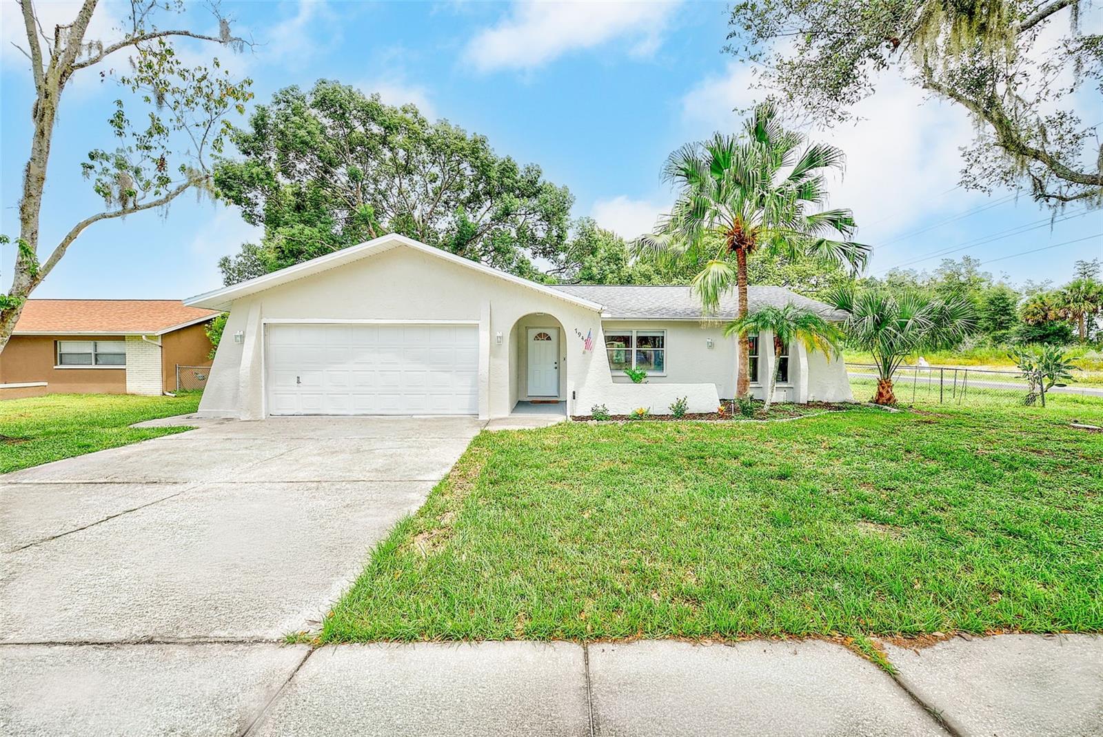 Just what you have been waiting for! Beautifully refreshed and fully updated 3-bedroom, 2-bath home situated on a spacious corner lot with just under a quarter-acre of fully fenced yard. Featuring a desirable split-bedroom floor plan and extensive updates throughout, this move-in ready home offers the perfect combination of comfort and functionality. The open living room flows seamlessly into the dining area with convenient access to the backyard. The updated kitchen features white shaker cabinets, stone countertops, stainless steel appliances, and a breakfast bar. The spacious primary suite offers a wall of closets and an updated en-suite bathroom. Two additional bedrooms are located on the opposite side of the home with a beautifully updated guest bathroom nearby. Recent improvements include a brand-new roof (2026), fresh interior and exterior paint, new vinyl flooring throughout, updated bathrooms, new light fixtures, new ceiling fans, and brand-new interior doors. Outside, the fully fenced yard provides plenty of room to enjoy the outdoors and features dual gates and mature front-yard trees offering excellent shade. No HOA and located in a non-flood zone. Conveniently located near downtown New Port Richey, shopping, dining, parks, and major roadways for an easy commute. With so many updates already completed, all that's left to do is move in and enjoy. Don't wait on this one, homes this updated and move-in ready don't last long!