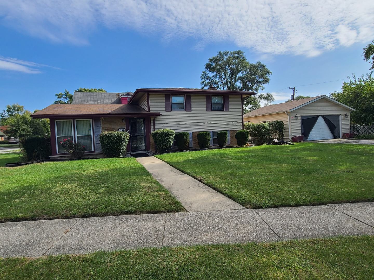A little updating can go a long way in this solidly constructed tri-level home with low taxes. The impressive corner lot has plenty of fenced yard space.  With cooler weather approaching, the separate formal dining room and large family room would be perfect for entertaining.  The lower level half bath makes it convenient for your guests.  There is an eat-in kitchen, hardwood flooring, and plenty of storage space.  The newer 2 1/2 car garage is oversized with a concrete slab foundation.  A home warranty is included with the purchase.  This property is being sold "as-is."