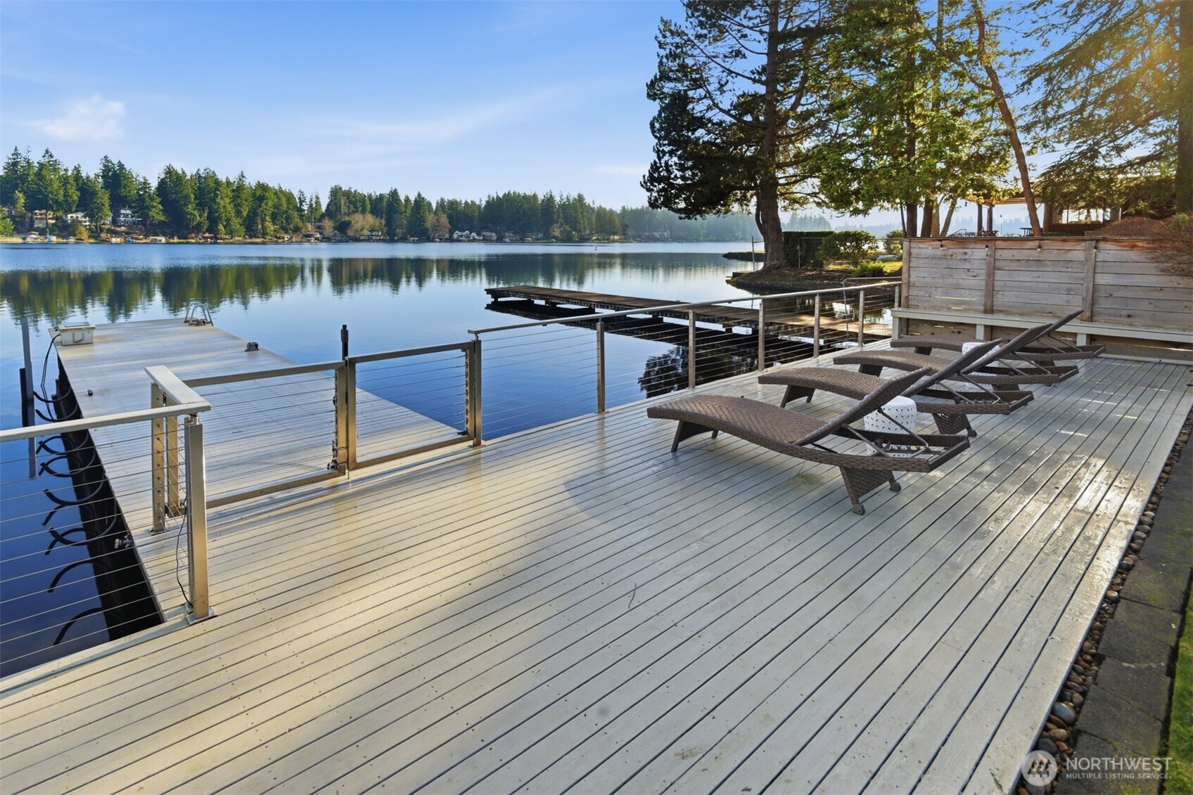 Experience the best of Lake Sawyer on a premier section of the lake with 55' of low-bank waterfront. This perfectly positioned home offers an effortless connection to the water, where the kitchen and living areas flow directly onto the expansive deck and flat backyard for easy lakeside entertaining. The 1,440 SF main house features floor-to-ceiling windows and a private dock with a boat lift. A massive 1,000 SF shop offers 3 bays, 10' doors, and 14' ceilings, ideal for boat or car storage. Included is a 562 SF DADU with a full kitchen, perfect for guests or an office. With two fenced yards and 2,002 SF of total finished space, this Black Diamond compound provides rare accessibility and unmatched utility in a coveted location.