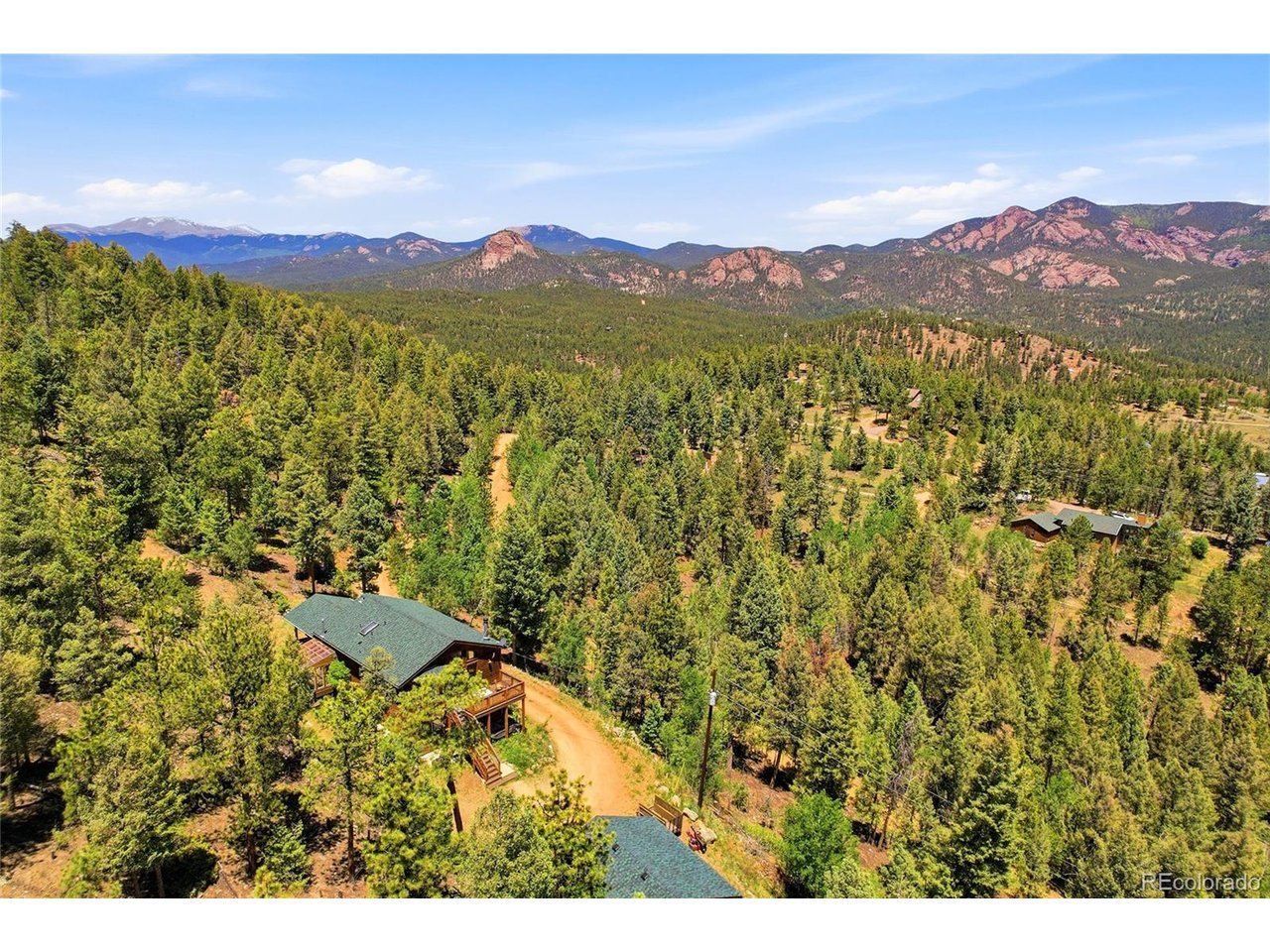 Perched at the end of a quiet road and surrounded by towering pines, this exceptional mountain retreat offers breathtaking views overlooking the protected landscapes of Staunton State Park. With extraordinary vistas from nearly every window, unmatched privacy, and direct access to Colorado's outdoor lifestyle, this property delivers the mountain experience buyers dream about. Built in 2002, the thoughtfully designed home features 2 bedrooms, 2 bathrooms, hand-scraped hickory hardwood flooring, and a dedicated office with inspiring views, perfect for remote work. The inviting living area centers around a cozy wood-burning stove that creates warmth and helps reduce utility costs during the winter months. The kitchen features a GE Monogram gas range with four burners and griddle, while the primary suite includes an Elfa closet organization system. Outdoor living is where this property truly shines. The remarkable 16x16 covered composite deck, complete with under-eave heaters, feels like a private mountain lodge and provides the perfect setting for dining, entertaining, and year-round enjoyment. A separate front deck captures the morning sun, while a level area wired for a future hot tub awaits your vision. The sunroom and greenhouse feature Pella windows, a built-in greenhouse fan, and sun screen, creating an ideal space for gardening enthusiasts. The detached two-car garage includes custom-built storage bins, and the property offers usable outdoor space for recreation, birdwatching, wildlife viewing, and even disc golf. A retaining wall crafted from Pikes Peak pink granite adds character and functionality to the landscape. Located just minutes from Staunton State Park, Pine Valley Open Space, Safeway, and endless opportunities for hiking, mountain biking, fly fishing, climbing, kayaking, hunting, and more, this home offers the perfect balance of seclusion and convenience. Protected views, peaceful surroundings and convenience make this a rare mountain offering.