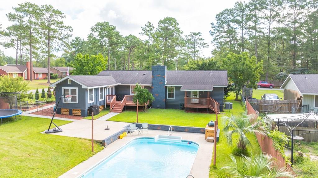 Looking for a backyard made for summer? This Thomasville home has you covered—with an in-ground pool, wired workshop, and garden space all on a fully fenced 0.39-acre lot in the county (no city taxes!).  Inside, you'll find 3 bedrooms, 2 baths, and 1,912 square feet of living space. The living room features vaulted ceilings, a functional wood-burning fireplace with a brick surround, and updated LVP flooring throughout most of the home. The galley-style kitchen includes freshly painted cabinetry, modern lighting, and a large window overlooking the backyard.  In addition to the three bedrooms, there's a separate room currently used as an office/game room—perfect for remote work or hobbies. There's also a large laundry room with tile flooring that could easily double as a playroom, man cave, or home gym.  Out back, enjoy your own private retreat with a vinyl in-ground pool, a wired workshop with window unit, and a garden area—everything you need to enjoy the outdoors without leaving home. Conveniently located just minutes from town, but with the space and privacy of county living.