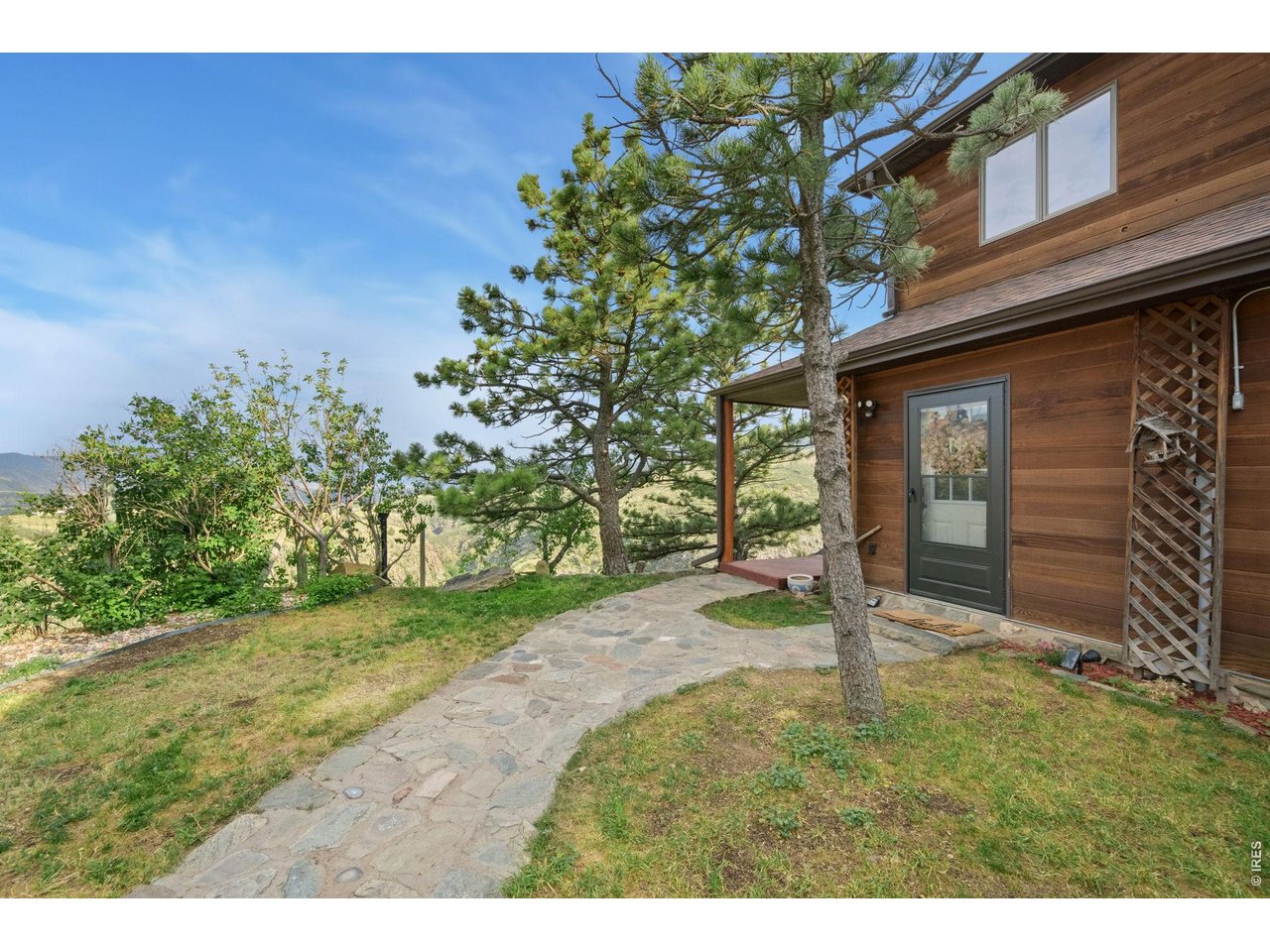 Tucked away at the end of the road for ultimate peace and quiet, 10828 Bears Lair Road offers a rare Colorado lifestyle on 55 beautiful acres that encompass both sides of Buckhorn Creek. This beautifully refreshed 4-bedroom, 2-bathroom mountain retreat is where nature meets modern comfort. Step inside to find gorgeous LVP flooring and large windows throughout that flood the home with natural light and frame the epic views. Cozy up by the living room's wood-burning fireplace on chilly evenings, or cook in the kitchen featuring a brand-new cooktop and stainless-steel refrigerator. Both bathrooms boast stylish 2021 updates. You will love retreating to the oversized primary bedroom, a peaceful space highlighted by warm wood ceilings and beautiful natural light. Need flexibility? One of the bedrooms is already perfectly set up as a home office, complete with built-in shelves and a clever Murphy bed for guests. Unwind in the cozy enclosed porch, step onto the wood deck to soak in the fresh mountain air, or relax in the brand new 6 person hot tub that overlooks the canyon and city lights at night. This property is an outdoor lover's dream, featuring its own hiking trail down to the water, private brook trout fishing, a peninsula picnic spot overlooking the canyon, and opportunities to harvest deer. Best of all, you can enjoy it all against a backdrop of panoramic views stretching across the Front Range, Horsetooth Natural Area, and Devil's Backbone. Complete with a versatile detached 2-car garage perfect for a workshop or studio, this home blends true mountain serenity with everyday comfort.