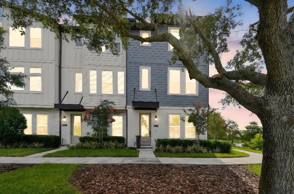Relax and enjoy water views from every room!  This bright corner lot, contemporary 3-story Ashton Woods Kilmer townhome is located in the heart of Laureate Park.

The open floor plan seamlessly connects the kitchen, dining and living areas, all adorned with luxury wood flooring. The kitchen is a highlight, showcasing a generous island with beautiful quartz countertops, tiled backsplash, contemporary quartz sink, sleek flat-panel cabinets, upgraded KitchenAid appliances, ample storage space with large pantry.  Relax out on the screened in balcony.

Over $100K in upgrades: automated shades throughout, pendant lighting over the kitchen island, matte plumbing fixtures throughout, upgraded bathrooms with auto flush tankless toilets, 6" baseboard throughout and plenty of storage throughout.
Media/Theater room (3rd bedroom) on ground level, along with cabinets/bar and drink refrigerator in hallway. Built-in fire safe in hall closet.

Each bedroom has its own attached bathroom, providing privacy and convenience.
Upgraded carpet and padding in all bedrooms.
Bedroom closets have custom wood shelving with builtin-in drawers.

The home features its own two-car garage with a EV charging station, overhead storage racks, and custom shelving, Q-home quite belt drive garage door opener.  The garage is fully insulated and sheet rocked.

The home features full home automation systems programmed and controlled from your smart phone:
doorbell and security cameras, fully automated window shades throughout, fully automated lighting throughout, automated thermostats which integrate monitored fire-security monitoring, automated electronic front door lock
Wall mounted large TVs mounted in all rooms are negotiable.

Close to resort-style amenities, you'll enjoy easy access to a community pool, a well-equipped fitness center, and the renowned Canvas Restaurant. This Lake Nona townhome offers luxury, convenience and the best of urban living in one of Orlando's most sought-after areas.