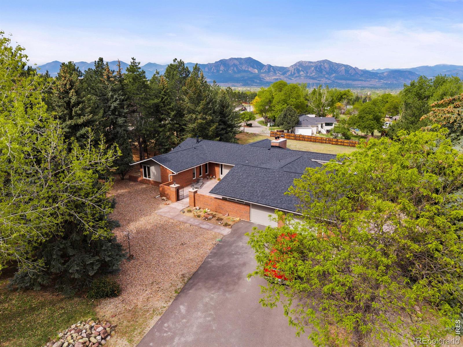 Nestled on 1.2 serene acres, this extensively renovated, open floor plan 4-bedroom ranch offers exceptional main-level living with sweeping mountain views and unforgettable sunsets framed by a dramatic west-facing wall of windows. Inside, the light-filled design features vaulted ceilings, expansive windows, main-level primary bedroom and laundry, recently painted interior and exterior, white oak hardwood floors and Taj Mahal quartzite counters. Living spaces are enhanced by three gas fireplaces.The gourmet kitchen was completely renovated in 2025 and is a chef's delight, featuring Taj Mahal quartzite counters, induction cooktop, double ovens enclosed in brick, maple cabinetry, tile backsplash, and an oversized walk-in pantry. The thoughtful layout of the home also includes three additional spacious bedrooms, a walk-out basement, and flexible living spaces ideal for entertaining or relaxing. A newly created oversized basement room offers potential for a theater, gym, storage or hobby space. Indoor/outdoor living is exceptional with a wraparound deck showcasing unparalleled views, a private covered patio, and a charming updated entry courtyard - all designed to enjoy the peaceful natural surroundings. Zoned Estate Residential (ER), allowing a variety of livestock uses. The yard is ideal for gardening, with a dedicated well for irrigation while city water serves the interior. Additional improvements include a new roof on the house and shed, 3 Mitsubishi ductless systems, updated bathrooms and whole house recessed lighting, finished 2-car garage with new concrete flooring, new electrical panel, 220V EV charging outlet, new irrigation well expansion tank, new septic tank and lines to the house. Located in a picturesque neighborhood with no HOA, this rare offering combines acreage, privacy, modern upgrades, and convenient access to Boulder, Louisville, and surrounding communities. This purchase includes 120 Ridge Road, 0.26 acres for a total of 1.2 continuous acres.