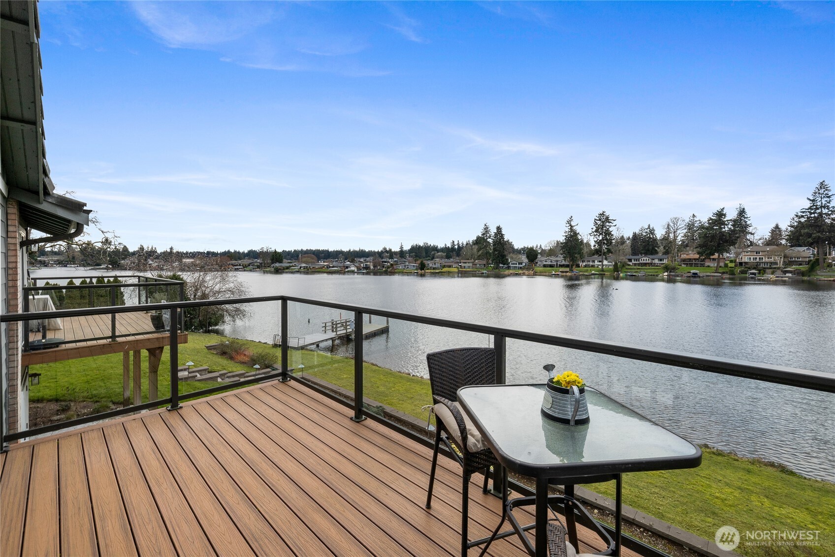 Enjoy breathtaking views of Lake Steilacoom from this beautifully updated waterfront condo. The open-concept design is filled with natural light and showcases vaulted ceilings, a cozy fireplace, and expansive windows that frame the lake.  The newly renovated kitchen features modern finishes, updated appliances, and stylish flooring, flowing seamlessly into the spacious living and dining areas. Step out onto the large deck to relax or entertain while overlooking the water.  Wake up to spectacular lake views from the primary suite, complete with a luxurious en-suite bath offering a Jacuzzi tub, separate shower, abundant storage, and a walk-in closet.  The lower level provides additional living space with a generous family room, bedroom, full bath, and patio with direct access toward the lake — perfect for guests or multi-generational living.  Enjoy shared access to the community dock for boating, swimming, and fishing. Additional highlights include a two-car garage and extensive updates throughout, including kitchen, bathrooms, appliances, flooring, and carpet.  Waterfront living at its finest!