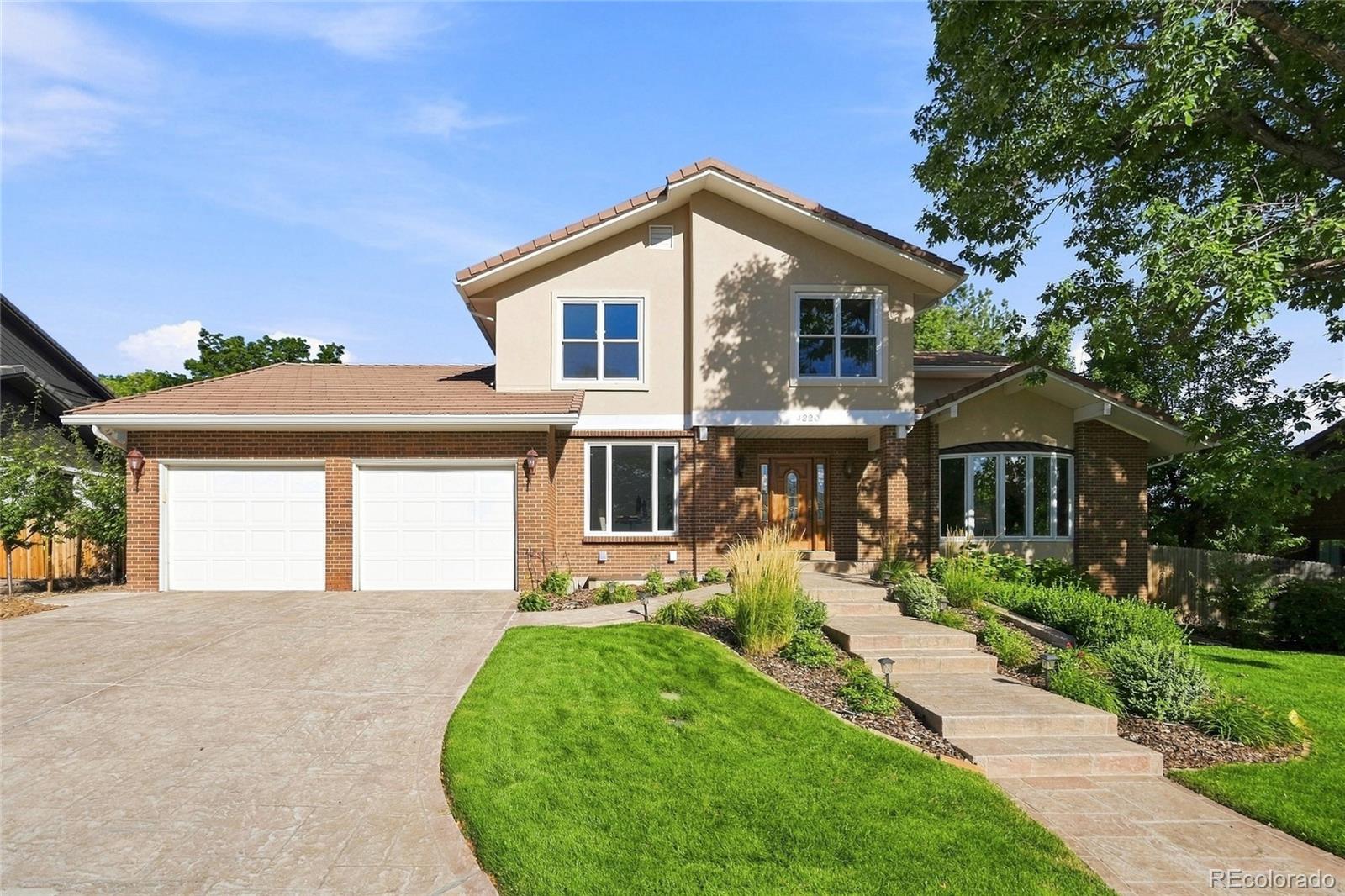 Beautifully updated in Marston Slopes, this spacious home combines timeless architecture with refined modern finishes and exceptional flexibility. The main level features hardwood floors, soaring vaulted living and family rooms, premium herringbone carpeting, a wood-burning fireplace with stove insert, and a striking office/library with wall-to-wall built-ins. The kitchen is finished with marble countertops and a premium Miele appliance suite with double ovens, steamer oven, warming drawer, built-in microwave, electric cooktop and dishwasher. A wet bar with wine refrigerator and ice maker adds another polished touch. Solid single-panel doors, upgraded millwork and a fully remodeled powder room carry the high-end feel throughout.Upstairs, the primary suite offers high ceilings, a walk-in closet and spa-like bath with heated floors, BainUltra jetted tub overlooking the treetops, dual vanity and glass-enclosed steam shower. The secondary bath is also remodeled, while herringbone carpeting and barn-style closet doors continue throughout the upper level.The permitted lower level lives like a true additional floor, with abundant natural light, a large living area, bedroom, additional flex/guest room, full bath with walk-in shower and dual vanity, laundry hookups, and a beautifully finished kitchenette with full-size refrigerator, sink, cabinetry, tile backsplash and granite counters.Outside, the private backyard is framed by mature spruce and other trees and includes a covered patio and walking path. A six-tree orchard with apple, apricot, cherry, plum and peach joins producing raspberry, blackberry and strawberry beds, all served by a 7-zone app-controlled B-hyve irrigation system. Roses and perennial plantings surround the property. A complete Lennox HVAC system—two-stage variable-speed furnace, central A/C and whole-home humidifier—was installed in 2025. Two-car attached garage. Minutes to shopping, Red Rocks and mountain recreation.