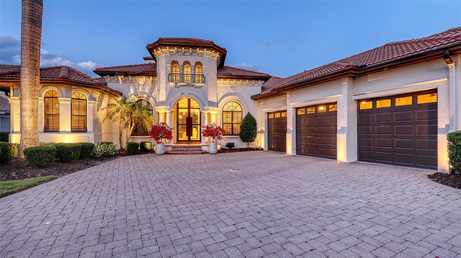 Live the Lifestyle You've Been Dreaming Of in Lakewood Ranch Country Club!

Perfectly positioned on one of the premier homesites in Lakewood Ranch Country Club, this exquisite custom-built estate offers panoramic views of the shimmering lake and rolling fairways—setting the tone for an extraordinary living experience. Encompassing nearly 5,000 square feet of refined interior space, this residence effortlessly blends timeless elegance with modern updates.

From the moment you arrive, you're greeted by stately iron double doors that open to a grand foyer, where soaring ceilings, graceful archways, and rich architectural details unfold. The formal living room is a showstopper with coffered ceilings, a gas fireplace framed by a stone mantle, and picture-perfect views. Host with ease in the formal dining room or indulge your inner chef in the gourmet kitchen, showcasing Brookhaven cabinetry, quartz countertops, a striking quartz backsplash, 6-burner gas cooktop, pot filler, double ovens, warming drawer, and an expansive walk-in pantry—complete with a second refrigerator.

Retreat to the luxurious primary suite with custom-built walk-in closets, a double tray ceiling, engineered wood floors, and tranquil views. The spa-like bath offers a Roman shower, jetted tub, dual vanities with granite counters, and richly appointed cabinetry. Two additional en-suite bedrooms on the main floor provide privacy and comfort for family or guests, while the dedicated office with custom built-ins and a spacious bonus room with sliders to the lanai add flexibility to suit your lifestyle.

Upstairs, a fourth bedroom, full bath, and media/bonus room with access to a balcony offer the ideal setting for guests or a private retreat, with sweeping views that must be seen to be believed.

Step outside to your private backyard oasis where the expansive lanai is designed for year-round enjoyment. Lounge by the saltwater pool and spa, entertain under the covered outdoor living spaces with a fully equipped summer kitchen, or gather around the outdoor fireplace for cozy evenings under the stars.

Located within the gates of Lakewood Ranch Country Club, residents enjoy access to optional memberships to world-class amenities including 4 championship golf courses, a state-of-the-art fitness center, tennis and pickleball courts, fine and casual dining at the private clubhouses, and a vibrant social calendar.
Beyond the gates, Lakewood Ranch is consistently ranked as one of the top master-planned communities in the country, offering top-rated schools, medical facilities, scenic parks and trails, and a thriving Main Street with shopping, dining, and entertainment—all just a short drive to the white sand beaches of the Gulf Coast.

This is more than a home—it's a statement of lifestyle, elegance, and Florida living at its finest.