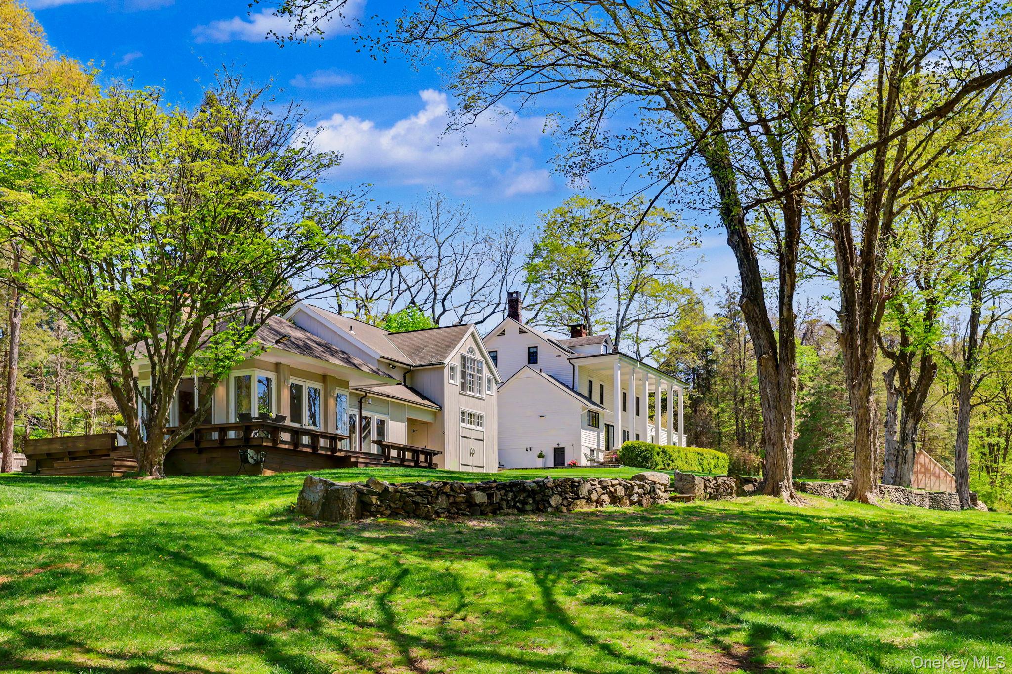 Some properties simply cannot be recreated.They are collected over centuries. Layer by layer. Story by story. Stone by stone.Set behind towering trees and abutting hundreds of protected acres of the Mianus River Gorge Preserve, this exceptional Bedford estate offers a rare opportunity to own a thoughtfully restored historic property surrounded by natural beauty and privacy.Dating back to 1825, the historic main residence was once part of a larger Long Ridge Road estate and formerly operated as the Wilkenloh Hotel in the early 19th century. Today, the home has been tastefully renovated and refreshed, blending timeless architectural character with modern comfort and functionality.As you enter through two dramatic stone entry boulders, a winding gravel driveway leads to the main residence, separate cottage and expansive grounds featuring rolling lawns, mature trees and historic stone walls. Set on over 5.5 acres, the property offers a peaceful setting with scenic landscape views in every season.Inside the main residence, original wide plank floors, a natural stone fireplace and gracious living spaces showcase craftsmanship rarely found today. Walls of windows and glass doors fill the home with natural light while framing picturesque views of the surrounding property. The open-concept kitchen, dining and family room create an ideal layout for everyday living and entertaining.A covered rocking-chair porch supported by stately pillars overlooks the property and provides a tranquil setting to enjoy the changing seasons of Bedford.Outdoor amenities include a restored 22x44 heated gunite pool with updated mechanicals and an expansive 1,400+ square foot pool house featuring wraparound decking, outdoor fireplace, screened-in entertaining area with fireplace, wet bar, ice machine, full bath, kitchenette and flexible guest or recreation space.The separate cottage offers its own private driveway entrance and features cathedral ceilings, a palladium window, kitchen, full bath, garage, additional flexible-use rooms and extensive storage space, ideal for guests, home office use, or extended living arrangements.Additional highlights include bluestone patios, restored landscape features and a private three-acre trail system suitable for walking, jogging, mountain biking and outdoor recreation.Conveniently located near Bedford, major roadways, shopping, dining and Metro North train access, this unique Westchester County property offers a rare combination of historic character, updated amenities, flexible living space and exceptional natural surroundings.square footage consitst of:  4017sqft of total living space includes 5 bedrooms, 3.5 baths, cottage (independent assessor 834sqft attached documents) includes  kitchen, bath, 2 rooms with garage below and separate driveway entrance.  Pool house, 2 car garage below, heat pump air, playroom, bath, kitchenette, 3/4 wrap-around deck overlooking pool, screened in stone patio with fireplace (1469 sqft