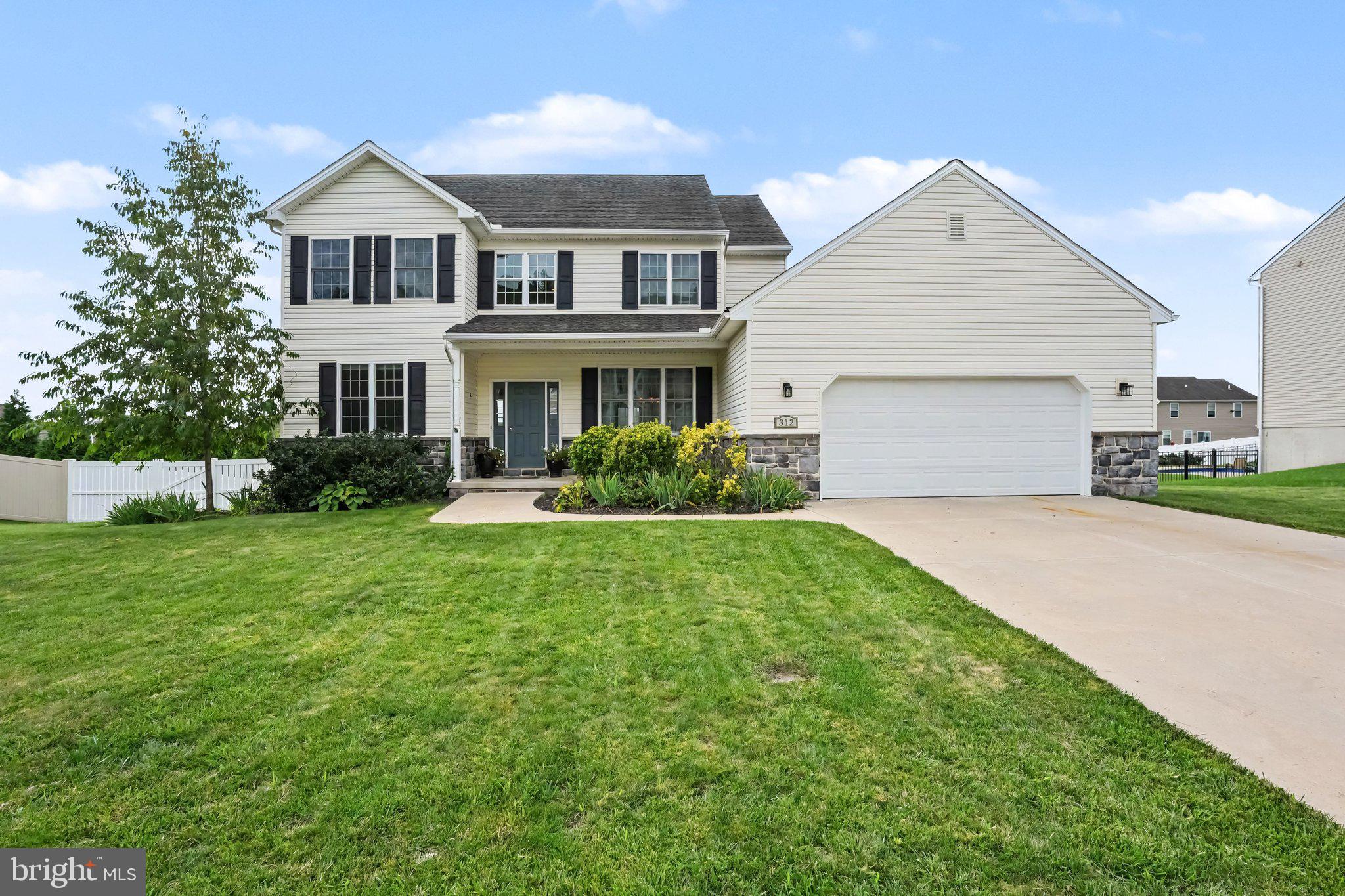 Welcome to 312 Braddock Drive, Etters, PA 17319—an inviting 2013 traditional home in the highly sought-after Woodbridge Farms community, where sidewalks, a nearby park, and an easy I-83 location put Harrisburg and York within comfortable reach. From the first step inside, the home feels both polished and livable: a formal entry opens to a dedicated dining room and a separate living room, giving you the presence of distinct entertaining spaces without sacrificing everyday flow. At the heart of the home is an expansive eat-in kitchen built for gathering. A central island with breakfast bar, generous table space, recessed lighting, and high-end appliances—including a double-door oven, cooktop, dishwasher, and microwave—make weeknight dinners and weekend hosting equally easy. The kitchen opens directly into a spacious family room anchored by a gas fireplace and an elegant mantel, the natural place for movie nights, homework, and conversation. Upstairs, the primary suite is a true retreat, with a large walk-in closet and a private bath featuring a soaking tub, step-in shower, and double-basin vanity. Three additional bedrooms, a full hall bath, and a convenient second-floor laundry area complete a well-planned upper level that works for family living, guests, or a home office. The finished walk-out lower level adds even more flexibility: a large recreation room for play, fitness, or media, plus generous storage and direct access to the rear yard. Outside, the landscaped 0.29-acre lot with a fenced-in rear yard is ready for entertaining, with extensive hardscaping, a patio and deck for outdoor dining, and a hot tub for year-round unwinding. An attached two-car garage with opener and a concrete driveway keep daily life simple, while a leased photovoltaic solar array supports energy-efficient living. Thoughtfully finished, comfortable, and ready for its next owner. Great place to call HOME!