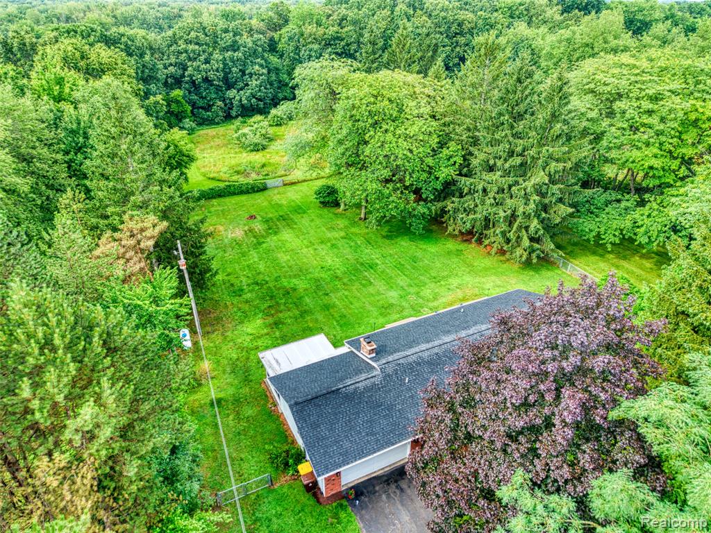 Calling all outdoor enthusiasts! This private, updated ranch sits tucked back off the road on just over 13 beautiful acres — the perfect blend of open space and wooded serenity. Located approximately 18 miles from downtown Lansing and only 5 miles from I-69, this property offers both privacy and convenience. Enjoy summer gatherings on the newly built deck (2022) or relax year-round in the hot tub located in the inviting three-seasons room. An oversized shed provides plenty of space for all your yard tools and outdoor gear. Inside, you’ll find a bright and welcoming home filled with updates, including new flooring, trim, carpet, paint, and light fixtures throughout. The kitchen features stainless steel appliances, a new sink (2025), and modern fixtures and flooring. The stove with convection oven and sink are brand new in 2025, while the fridge and dishwasher are only 5 years old. Both bathrooms have been tastefully updated with modern vanities and fixtures. Enjoy peace of mind with major system updates including Furnace and AC/Heat Pump (2021) – with transferable warranty, New sump pump (2023), Roof replaced (2019), Generator plug for added security during power outages. Abundant natural light fills the kitchen, dining, and living areas through the brand-new, black-framed windows, offering stunning views in every direction. The unfinished basement provides excellent potential for future living or entertaining space. Located in the Bath school district, with school of choice available at Laingsburg Schools, this home is efficient, updated, and truly move-in ready. Septic pumped June 2025. Whether you’re looking for peaceful country living, room to explore, or the perfect setup for outdoor recreation — this property has it all.