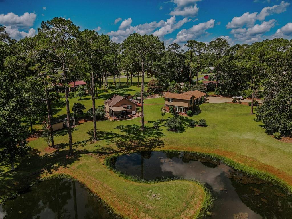 MUST SEE TO BELIEVE! A rare in-town retreat where privacy, natural beauty, and thoughtful design come together on 2.88 beautifully landscaped acres with a MAIN house & GUEST cottage, BOTH TOTALLING 2,880 sf. Centered around a picturesque pond and surrounded by professionally designed landscaping and an impeccably manicured lawn, this one-of-a-kind property offers a peaceful setting just minutes from schools, healthcare, and everyday conveniences.    The approximately 2,018-square-foot tri-level MAIN home completely remodeled in 2013(including new wiring, plumbing and insulated windows) is designed to embrace the outdoors with abundant windows that frame stunning pond views throughout and has 3 bedrooms & 2 bathrooms. The main level features a cozy and inviting kitchen, breakfast room and dining area, along with the private primary suite. Just a few steps down, the spacious living room is highlighted by a gas log fireplace and dramatic floor-to-ceiling windows that create a seamless connection to the surrounding landscape. Upstairs, two additional bedrooms share a well-appointed hall bath, providing comfortable accommodations for family or guests. NEW ROOF IN MAY 2026.       The 862-sf GUEST cottage built in 2016 is appointed for long term or short-term needs including spacious living, bedroom, and eating areas all within the open concept design. The kitchen has all you need to prepare meals with a small refrigerator, two induction cook tops and a microwave.  The bathroom has a double sink vanity, separate shower plus a large soaking tub. The oversized walk-in closet is useful to the current owner by using part of the split closet as an office. Easy access to the pond view, patios (one which is covered) through the kitchen side door to enjoy the beautiful landscape. The cottage is situated just steps from the Main house back porch and is conjoined with beautiful pathways leading to a seating gazebo and grilling gazebo overlooking the amazing yard, including a Mediterranean inspired wall with built-in fireplace and storage.       Outdoor living further enhanced with a charming pergola complete with a fireplace, and a unique entertaining opportunity through the garage glass-paneled garage doors that open to the backyard, creating an ideal setting for gatherings in every season.     Whether you're entertaining guests, enjoying quiet evenings by the fire, or simply taking in the beauty of the professionally landscaped grounds, this exceptional property offers a lifestyle rarely found within the city limits. A truly special opportunity to own a private oasis with timeless appeal and unmatched outdoor beauty.