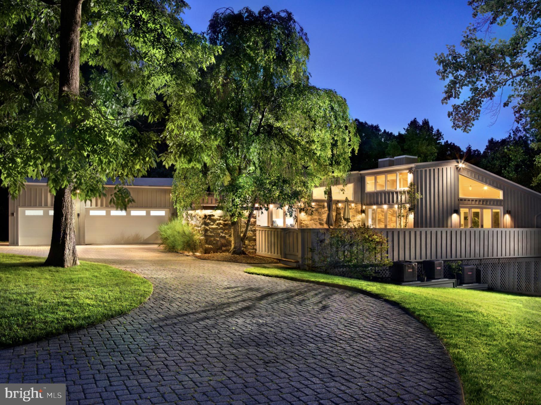 Contemporary architecture on the Main Line, near the end of a cul-de-sac on one of Gladwyne's most desirable streets. Designed by Campbell Thomas Architects in 1955, substantially renovated under prior ownership and further refined by the current owners, 1620 Monk Road pairs its architecture with the comfort and ease of a home built for everyday living. Soaring ceilings and walls of glass open the interior to light and landscape from every  room, while Pennsylvania fieldstone and rich Brazilian teak (cumaru) flooring ground the design in warmth and texture. The result is an open, flowing plan that is as livable as it is beautiful.From the foyer, the home unfolds into a large living room with multiple seating areas, a fireplace, and sight lines that frame views of the landscaped grounds. The dining room, kitchen, and breakfast room flow together with the same openness, and a family room with a second fireplace and a first-floor bedroom suite complete the level. Glass doors throughout connect the principal rooms to a wrap-around deck with multiple outdoor seating areas, so the living spaces extend directly into the landscape.The walk-out lower level is anchored by the primary suite, where an exposed stone wall and reeded wood detail bring texture and warmth. Its spa-like bath is appointed with a double vanity, a freestanding soaking tub, a separate shower, and exposed stone walls of its own. Additional bedrooms and baths follow, several carrying the same stone detailing, along with an exercise room and a laundry room. Five bedrooms and five full, one half baths in total.A circular driveway arrives through landscaped grounds. The wrap-around deck overlooks an in-ground concrete pool with fountains and a custom automatic cover, on a mature 0.84-acre parcel close to the village of Gladwyne and within easy reach of Center City. Three-zone heating and cooling throughout. Immediate possession available. Distinctive contemporary architecture, designed for warm, light-filled living.