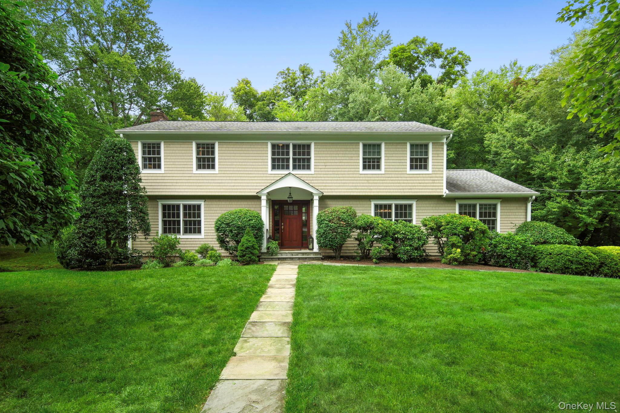 Perfectly positioned at the end of a quiet cul-de-sac, this beautifully maintained 4-bedroom, 2.5-bath Colonial offers the ideal blend of space, comfort, and effortless living—set on expansive, level property designed for both everyday enjoyment and memorable entertaining. A gracious foyer welcomes you, seamlessly opening to the living and dining rooms and creating a natural flow for gatherings. The living room features a stunning fireplace with custom built-ins, adding warmth and character, while the generously sized dining room is perfectly situated for easy access to the kitchen.The spacious eat-in kitchen serves as the heart of the home, offering room for an office or homework station and sliders that open to a large flagstone deck with awning—perfect for outdoor dining and relaxation. The inviting family room, complete with custom built-ins and direct deck access, enhances the home’s seamless indoor-outdoor lifestyle. A powder room and first-floor laundry add everyday convenience.Upstairs, the expansive primary suite is a serene retreat, featuring a well-appointed en-suite bath, a walk-in closet, and thoughtfully designed custom built-ins. Three additional generously sized bedrooms and a hall bath complete the second level.The walk-out lower level offers a recreation area, flexible space for a gym or office, a mudroom area with cubbies, abundant storage, and access to the three-car garage.The flat, expansive backyard—easily accessed from the deck, lower level, and a charming path from the driveway—provides exceptional space for recreation, entertaining, and relaxing in complete privacy.Enjoy the ease of cul-de-sac living with close proximity to schools, shops, and the train—an exceptional opportunity to call this special home your own.