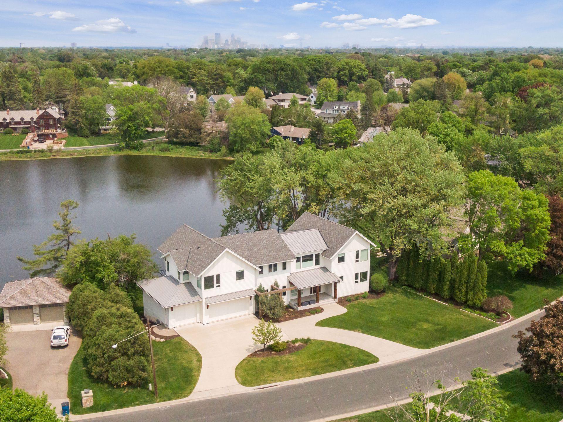 Designed with architectural discipline and structural precision, this Refined-built residence captures natural light and water views across Lake Harvey. Oversized windows, clean lines, hickory floors, and a linear fireplace define the open main level, anchored by a floating staircase with cable railing. The kitchen features honed granite and a retractable secondary island. A dramatic floor-to-ceiling sliding wall system allows the adjacent family room to open or close effortlessly — far beyond decorative doors. Oversized sliding glass doors open to an elevated deck with linear gas fire feature. Five bedrooms are located on the second level, each with a private ensuite bath with heated floor, plus a loft with water views. The walkout lower level offers heated floors, family room, wet bar, wine cellar, exercise room, jacuzzi room, and two additional bedrooms. Heated 4 car garage connects to mudroom and butler’s pantry. A home defined by proportion, precision, and thoughtful design.