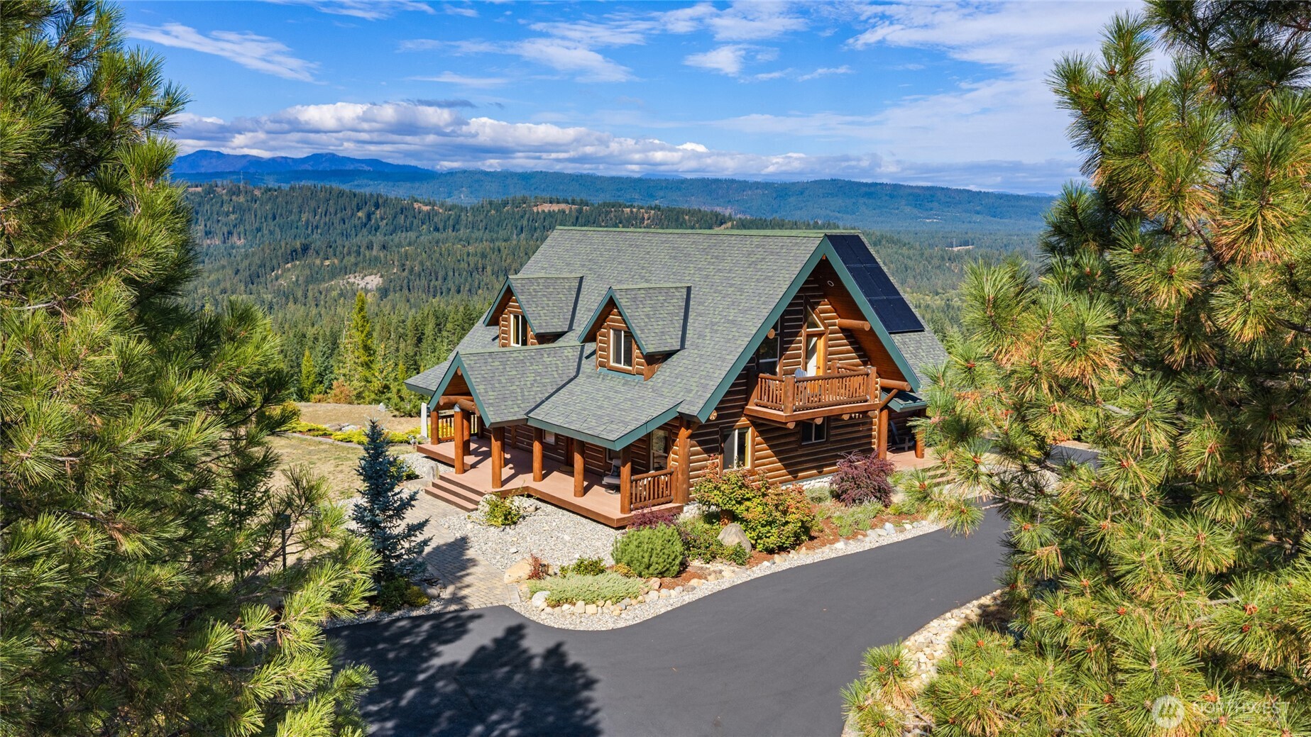 Set against a sweeping mountain backdrop, this log home offers a private setting, multiple outdoor living spaces, and beautiful natural surroundings.
