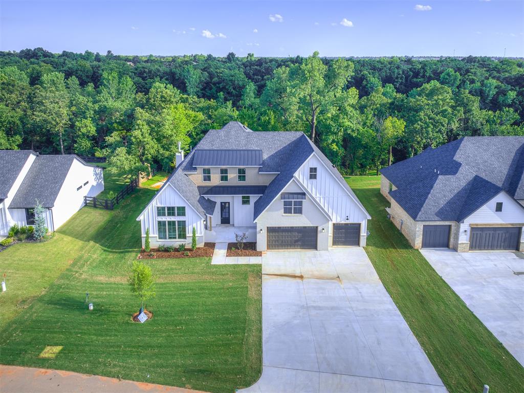 Welcome to your dream home! This stunning 4-bedroom luxury residence offers a perfect blend of elegance and comfort, designed for modern living. As you step inside, you are greeted by a grand foyer that leads to an expansive open-concept living area, flooded with natural light. The spacious family room features a cozy fireplace and large windows, creating a warm atmosphere for relaxation or entertaining guests. The gourmet kitchen is a chef's delight, equipped with high-end stainless-steel appliances, custom cabinetry, and a generous island with a breakfast bar, a butler’s pantry and a custom coffee station. The adjacent dining area provides ample space for family gatherings and dinner parties. Retreat to the luxurious primary suite, complete with a private en-suite bathroom featuring dual vanities, a wet room, which includes a soaking tub and walk-in shower, and a large walk-in closet. There are three additional bedrooms, one mother-in-law suite with private bath on the lower level, and two additional bedrooms and full bath are the second level, along with a large bonus room. On the first level is a dedicated study, offering a quiet space for work or study, overlooking the wooded backyard and wet weather creek - a serene backdrop for remote work or pursuing personal projects. Professionally designed, you’ll appreciate a neural color palette throughout with elevated tile sections, subtle pops of pattern and color, warm wood floors, and a designer light package, creating a high-end finish in every room. With an expansive back patio and a ¾ acre lot, there’s ample space for entertainment and play. Shop friendly and located within Edmond’s award winning school district. Up to $7,500 lender credit!