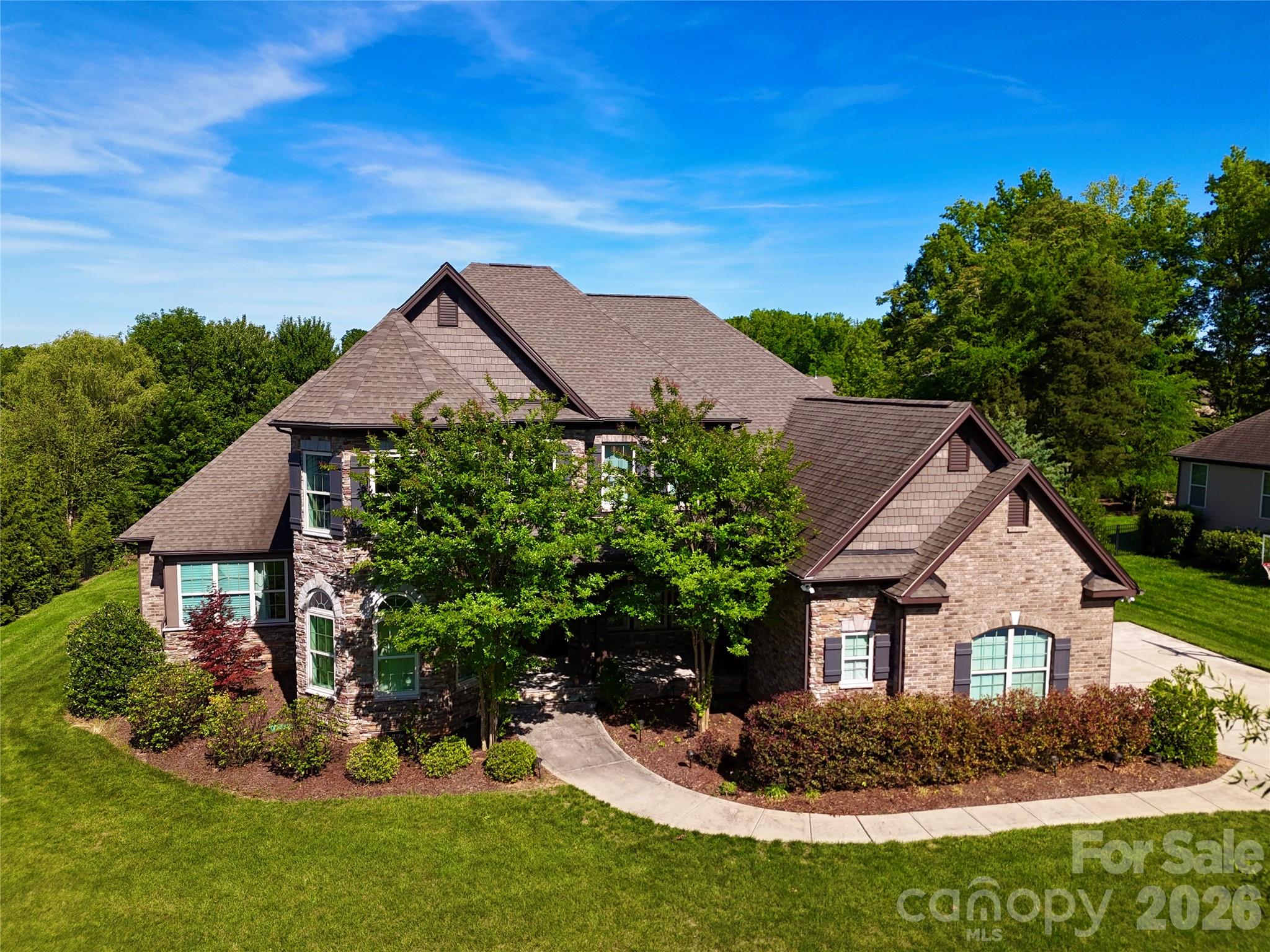 Beautiful, move-in ready 5-bedroom, 4-bath home in the sought-after Toll Brothers community, The Preserve at Marvin. Nestled within the highly regarded Marvin school district, this Raleigh model with farmhouse elevation and charming bay windows on both levels is filled with thoughtful upgrades and designed with families in mind.Step into a welcoming two-story foyer that seamlessly leads to an elegant formal dining room and a bright French-door study, both featuring bay windows that fill the spaces with natural light. The heart of the home is the grand, two-story great room, anchored by an upgraded stone fireplace and providing gorgeous views of the backyard.The main-level primary suite offers everything you could want for a relaxing retreat, including dual walk-in closets, a feature tub, and an upgraded walk-in shower. Also on the main floor is a guest bedroom with a full bath, making it a perfect setup for hosting friends or family.This home boasts impressive structural enhancements such as an extended great room, an expanded breakfast area, and a spacious kitchen. The gourmet chef’s kitchen is a true highlight, featuring an oversized island, expansive quartz countertops, upgraded soft-close cabinetry, double sinks, stainless appliances, a gas cooktop, a walk-in pantry, and an extended breakfast room that opens to the enlarged family room.Upstairs, you’ll find three generous bedrooms—one of which is oversized—accompanied by two full baths with quartz countertops and upgraded tile. The Jack-and-Jill bath includes a stand-up shower for added convenience. There’s also a versatile bonus/theatre room and upgraded closets in the primary and two upstairs bedrooms.Throughout the home, you’ll appreciate high-end touches such as hardwood floors on the entire first floor, designer flooring in the hall and family-room alley, recessed lighting and ceiling fans in every room, a practical drop zone, a spacious laundry room, and a three-car garage. Step outside onto the deck overlooking a large, flat backyard that’s perfect for play or entertaining.This home truly blends style, comfort, and function—ready for you to move in and make it your own!